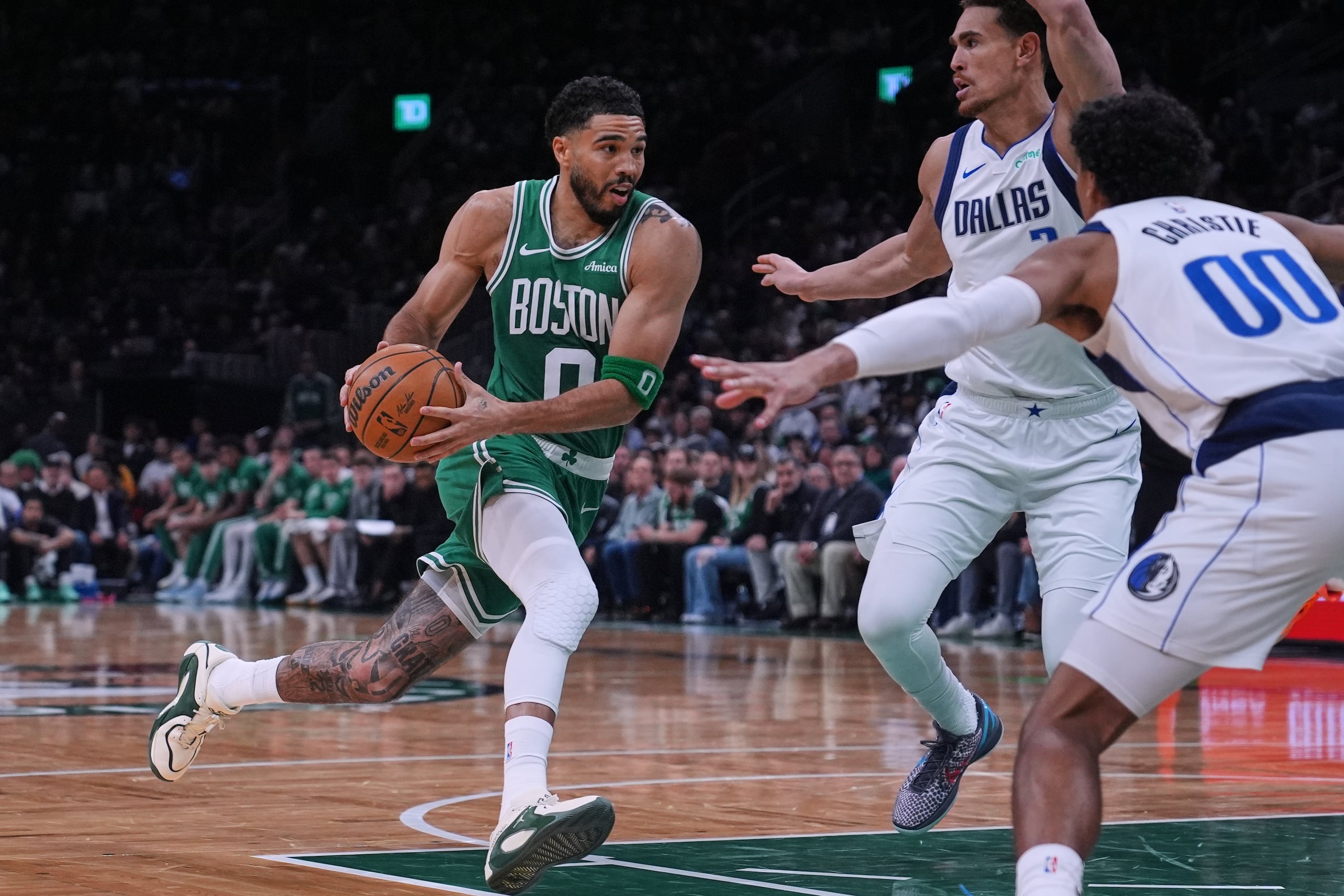Jayson Tatum, a la izquierda, controla el balón ante la defensa de Max Christie en su regreso a cancha después de 10 meses fuera por lesión.