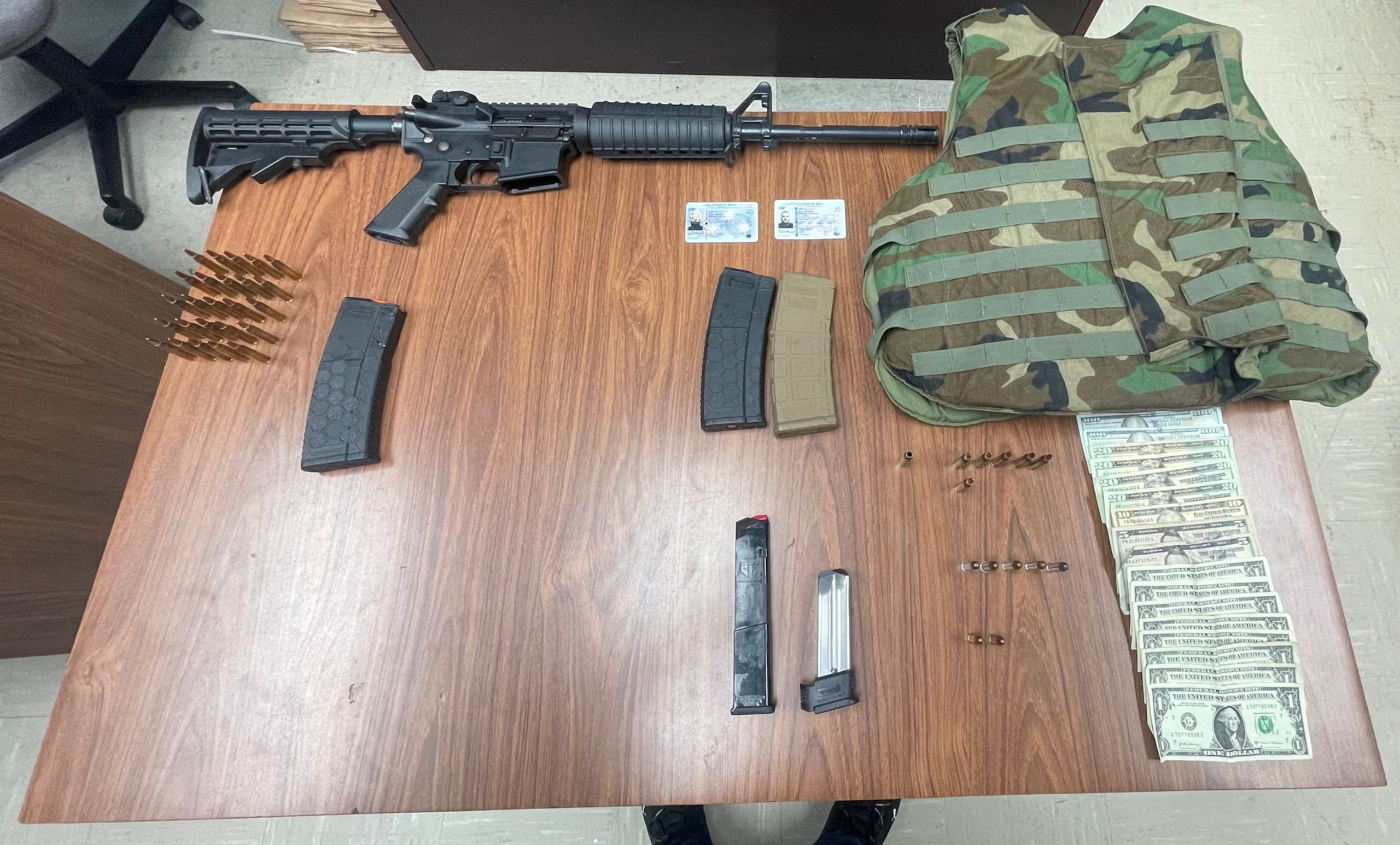 La foto muestra el rifle, los cargadores, las municiones y el dinero incautado en Vega Baja.
