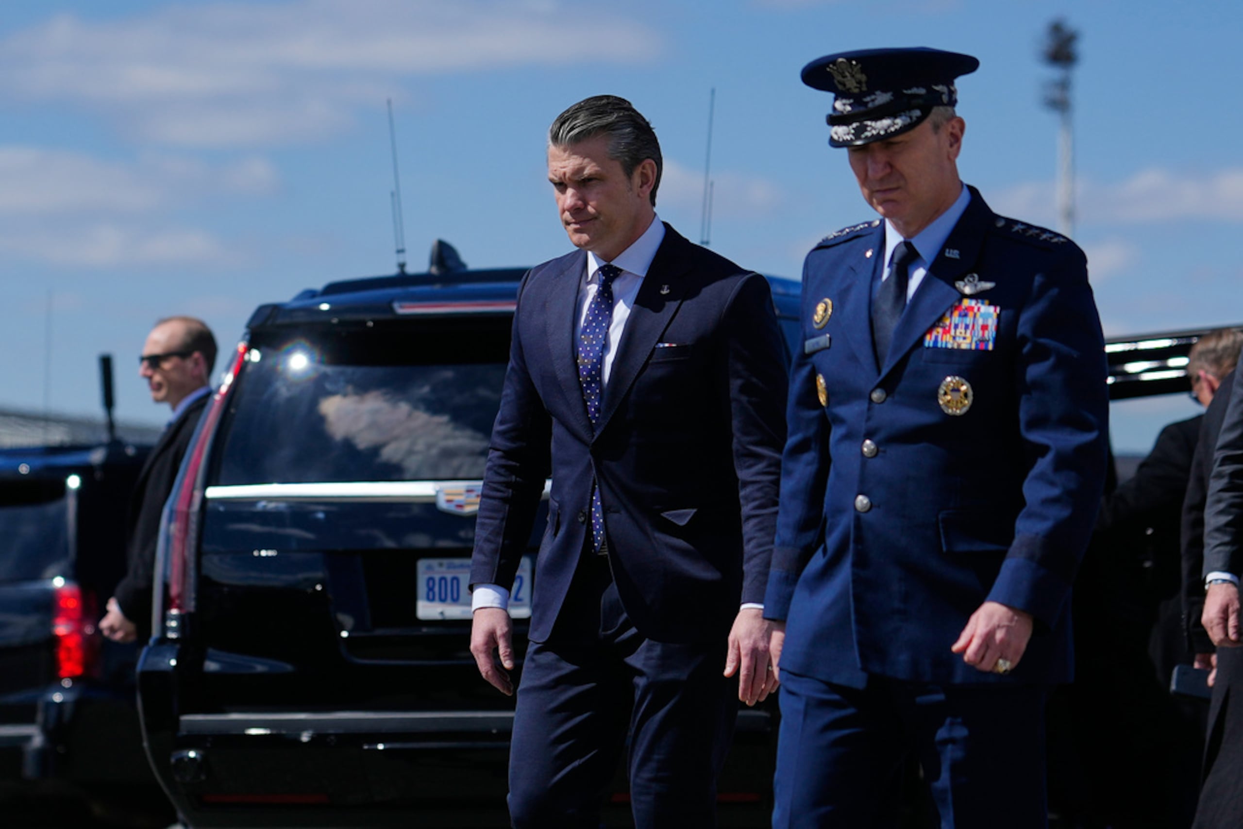 El secretario de Defensa, Pete Hegseth, y el presidente del Estado Mayor Conjunto, general Dan Caine, caminan tras llegar junto al presidente Donald Trump en el Air Force One, el miércoles 18 de marzo de 2026, a la Base Aérea de Dover, Delaware, para asistir al retorno de los restos mortales de los seis tripulantes de una aeronave de reabastecimiento de la Fuerza Aérea que murieron cuando su avión se estrelló en el oeste de Irak mientras apoyaban operaciones contra Irán.