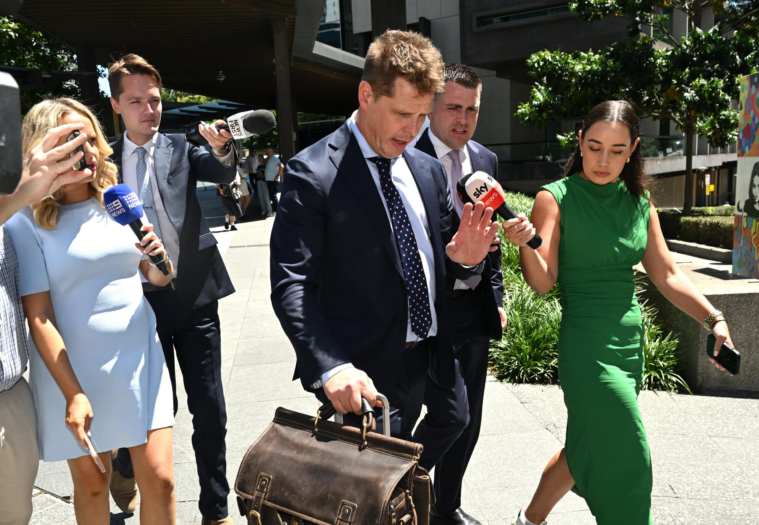 El abogado Mathew Cuskelly (centro), quien se encarga de la defensa de una instagramer australiana -cuya identidad no ha sido publicada- acusada de envenenar a su bebé de un año para conseguir seguidores y obtener donaciones.