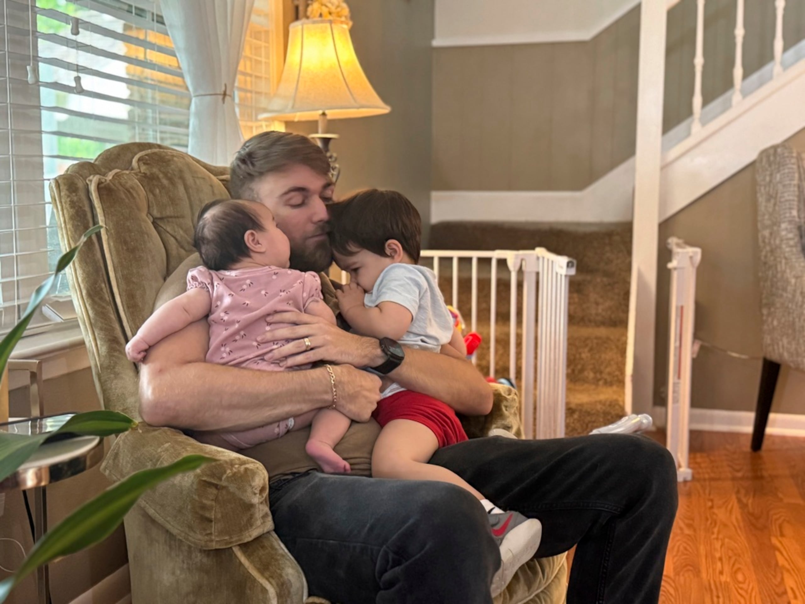 Adrian Clouatre abraza a su hija de tres meses, Lyn y a su hijo de casi dos años, Noah, en su casa en Baton Rouge, Luisiana.
