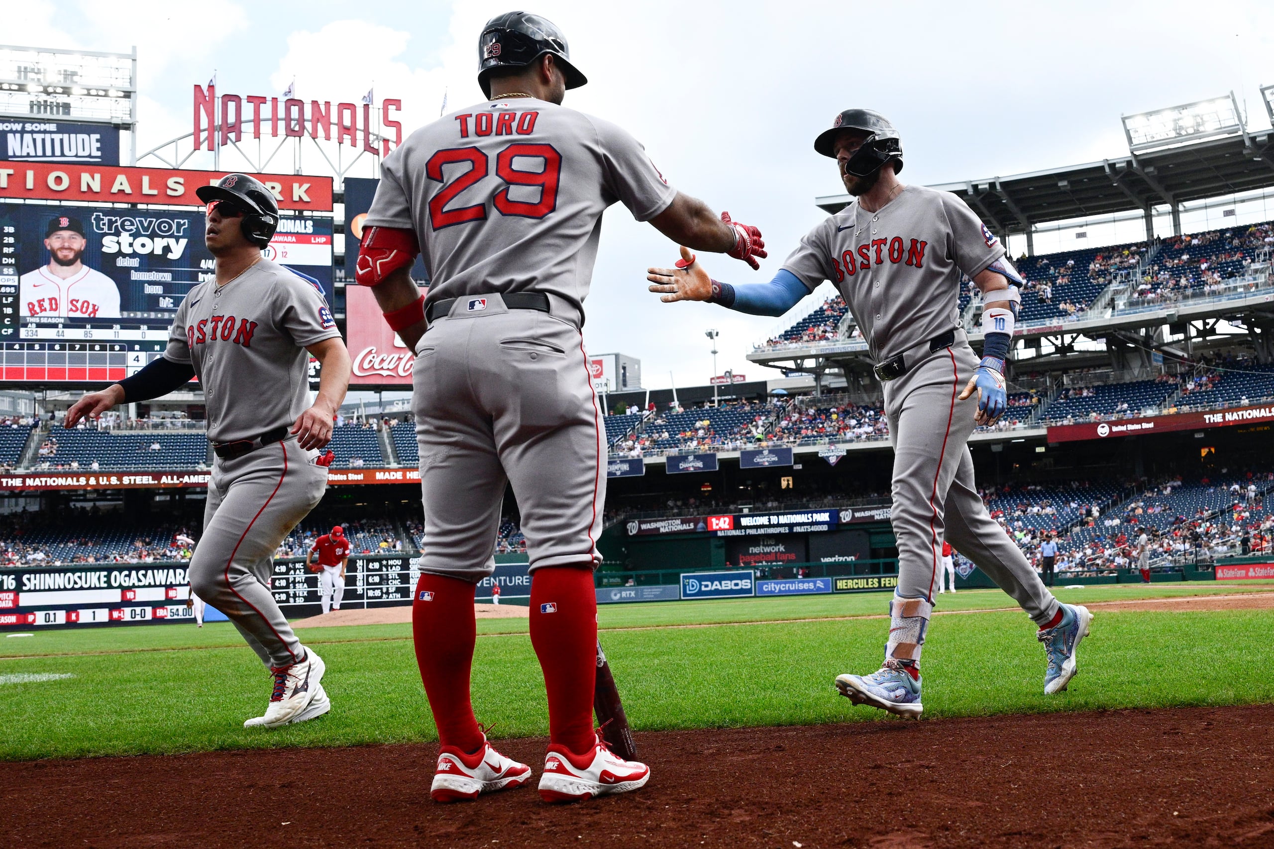 Trevor Story, derecho de los Red Sox de Boston, celebra después de su jonrón de dos carreras con Abraham Toro (29).