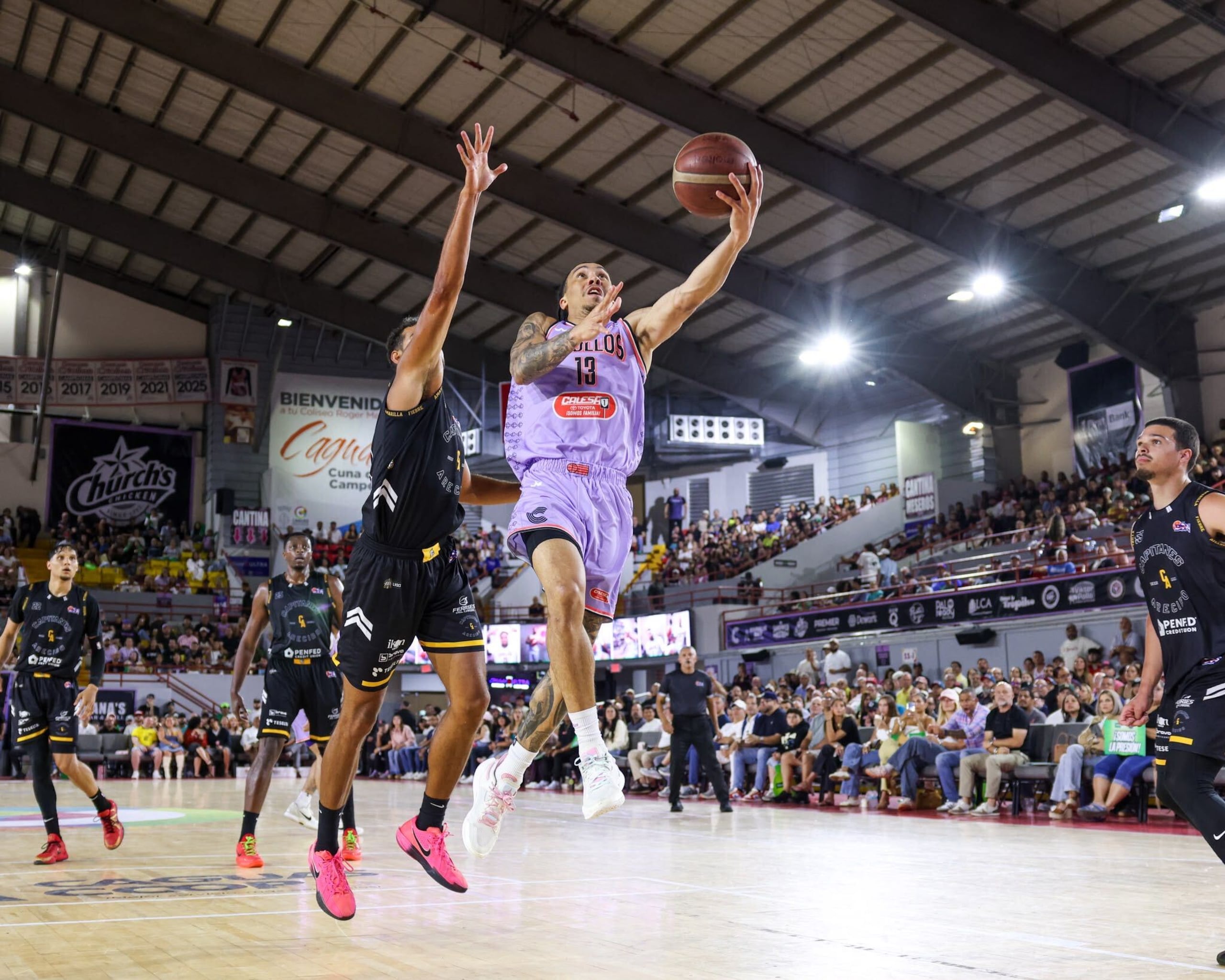 Travis Trice ataca el canasto ante la defensa de Timothy Soares en un juego entre los Criollos de Caguas y los Capitanes de Arecibo.