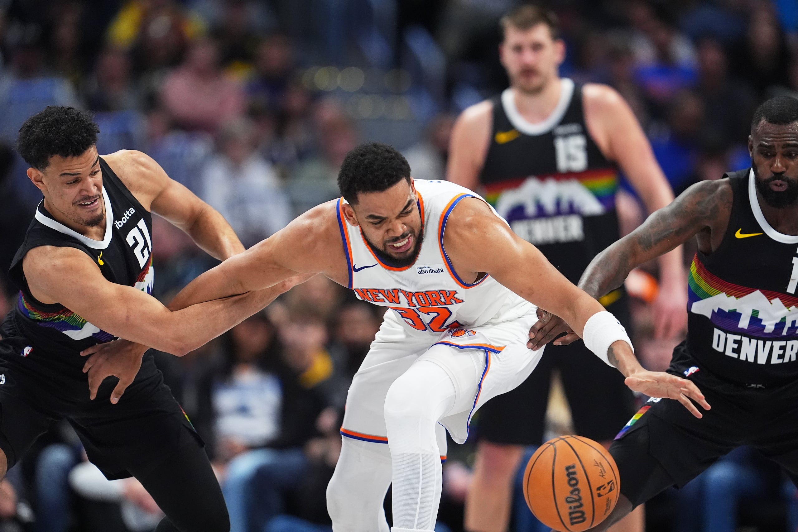 Karl-Anthony Towns, pívot dominicano de los Knicks de Nueva York, persique un balón entre Spencer Jones (izquierda) y Tim Hardaway Jr., de los Nuggets de Denver, el viernes 6 de marzo de 2026 (AP Foto/David Zalubowski)