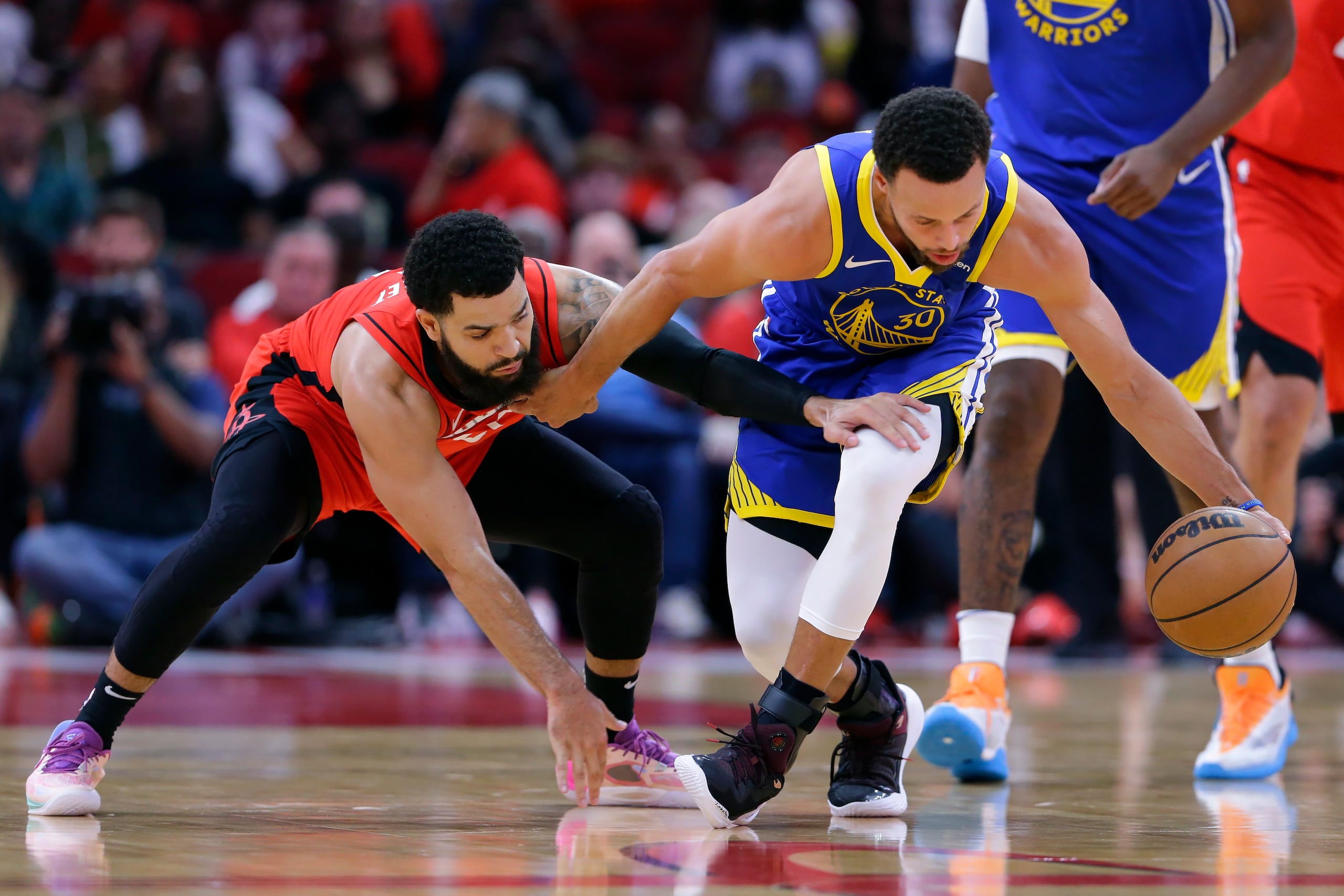 El base de los Warriors de Golden State Stephen Curry (derecha) trata de mantener control del balón ante la llegada del base de los Rockets de Houston, Fred VanVleet (izquierda) durante la 1ra mitad del juego en Houston, el domingo 29 de octubre de 2023. (AP Foto/Michael Wyke)