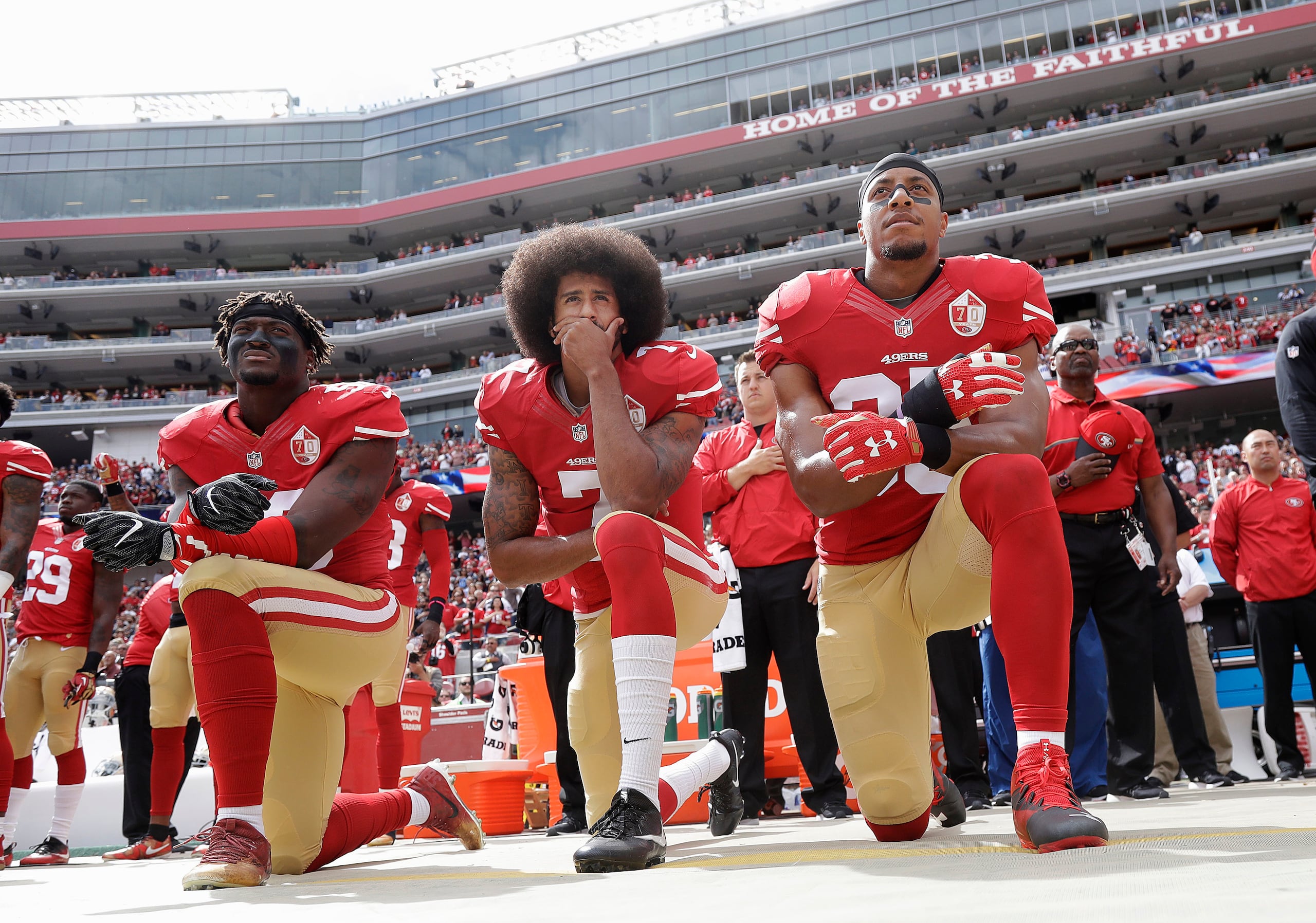Colin Kaepernick, al centro, se arrodilla durante el himno nacional antes de un juego de los 49ers de San Francisco.