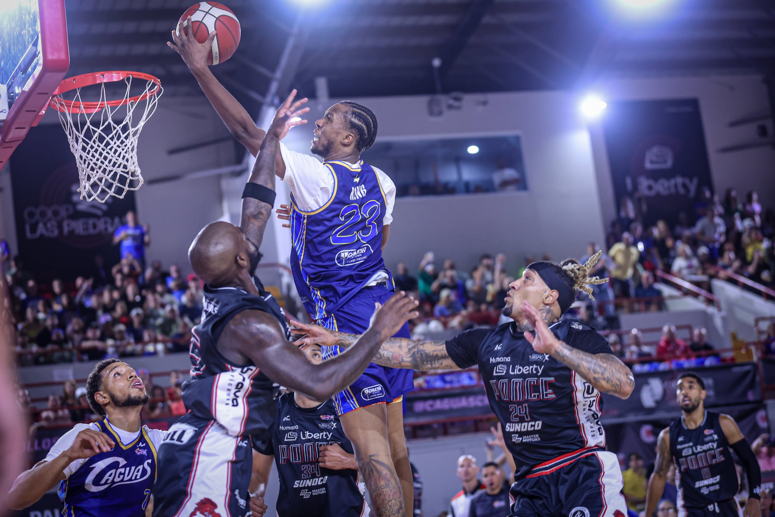 Louis King, refuerzo de los Criollos de Caguas, ataca el canasto ante la defensa de los Leones de Ponce.