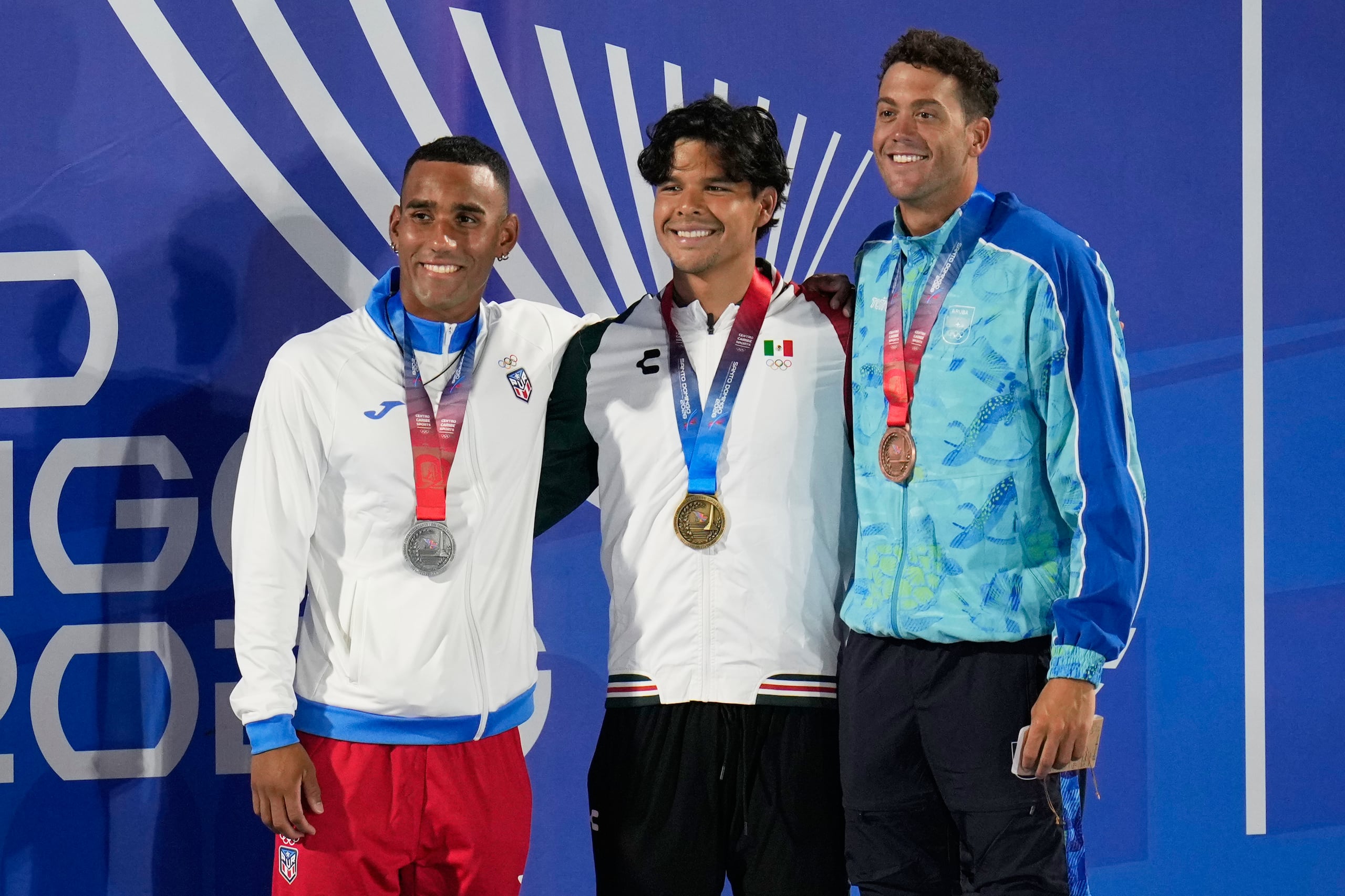 Yeziel Morales, a la izquierda, posa junto Humberto Najera de México y Patrick Groters de Aruba tras ser premiados por su evento de 200 metros espalda.