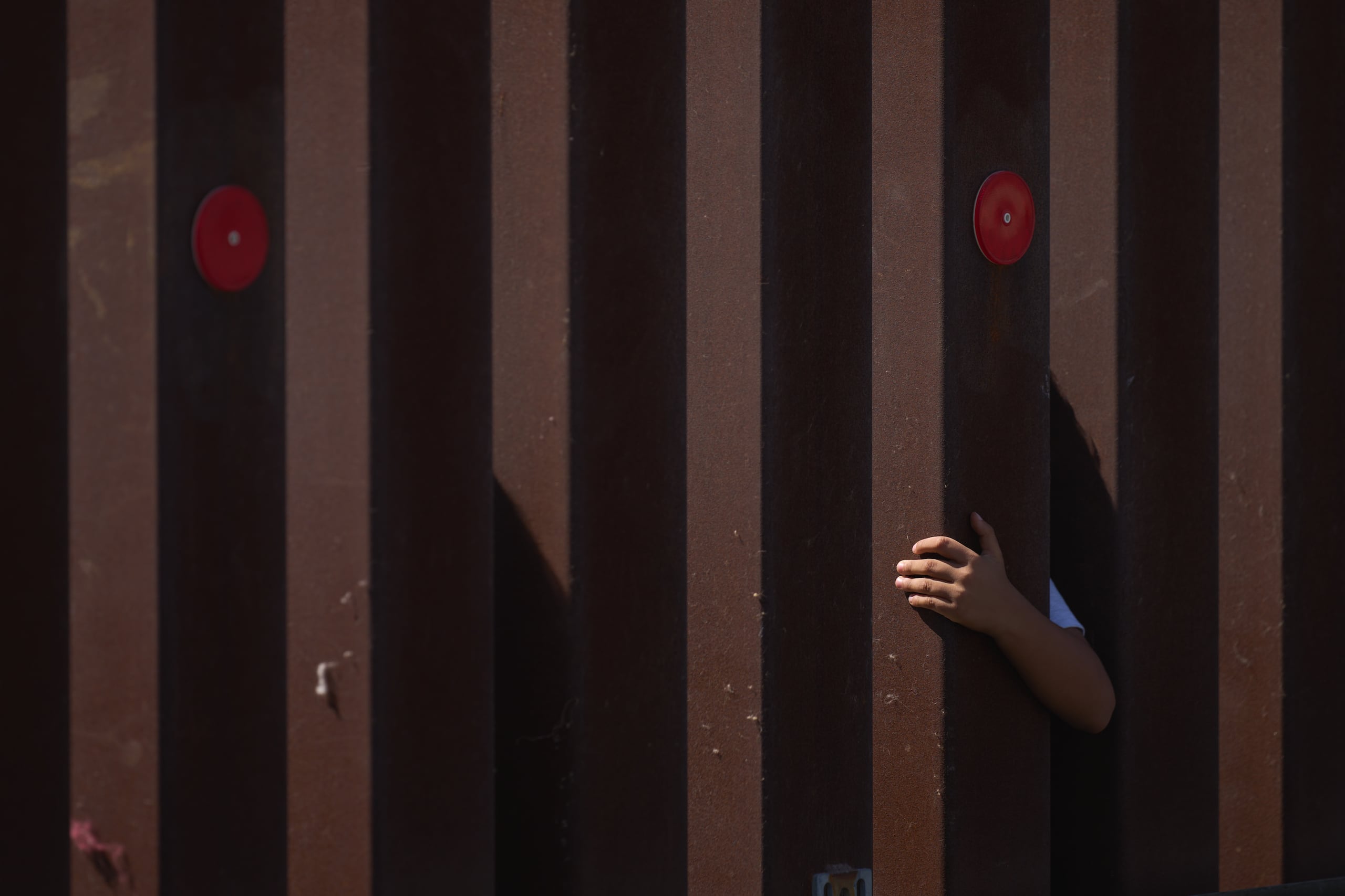 Foto de archivo que muestra a un niño se aferrado a la valla fronteriza de Estados Unidos mientras espera a la Patrulla Fronteriza entre las dos cercas en la frontera sur con México, en San Diego, California, en Estados Unidos. (EFE/EPA/ALLISON DINNER)