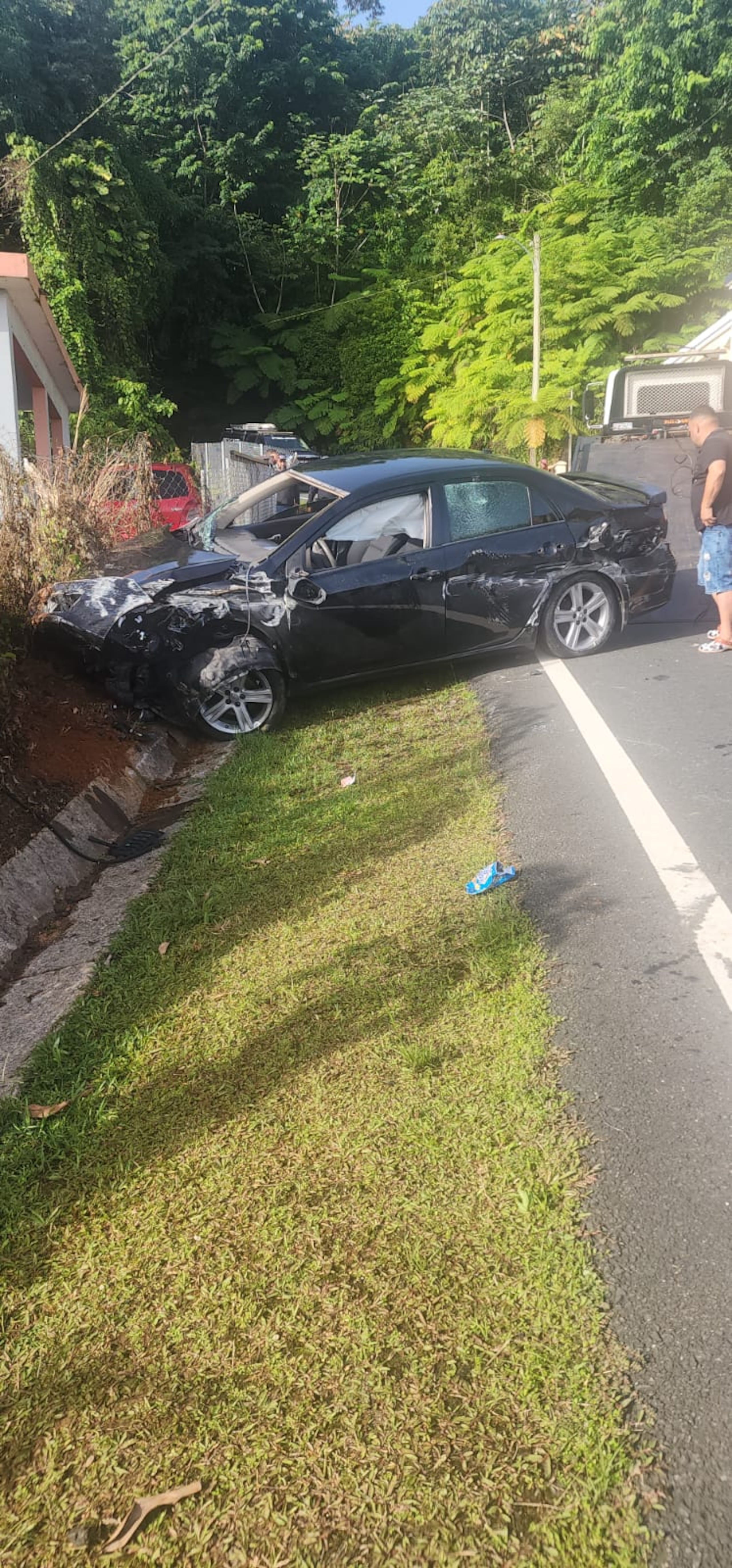 Imagen del accidente fatal ocurrido en el kilómetro 7.2 de la carretera PR-803 en el barrio Palos Blancos, en Corozal, mientras removían el automóvil.
