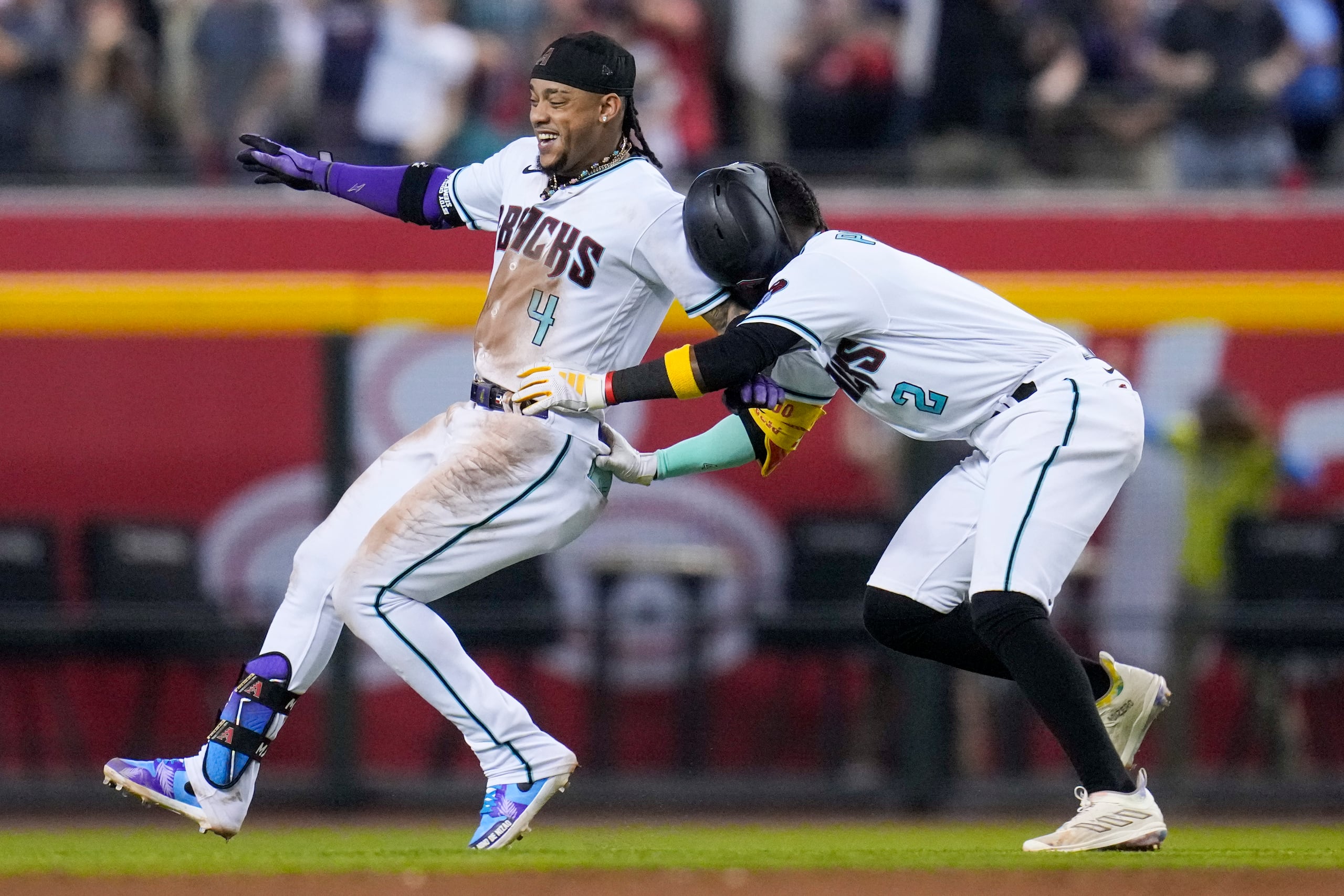 El dominicano Ketel Marte (izquierda) festeja con su compatriota Geraldo Perdomo tras conectar el sencillo que significó el triunfo ante los Phillies de Filadelfia en el tercer juego de la serie de campeonato de la Liga Nacional.