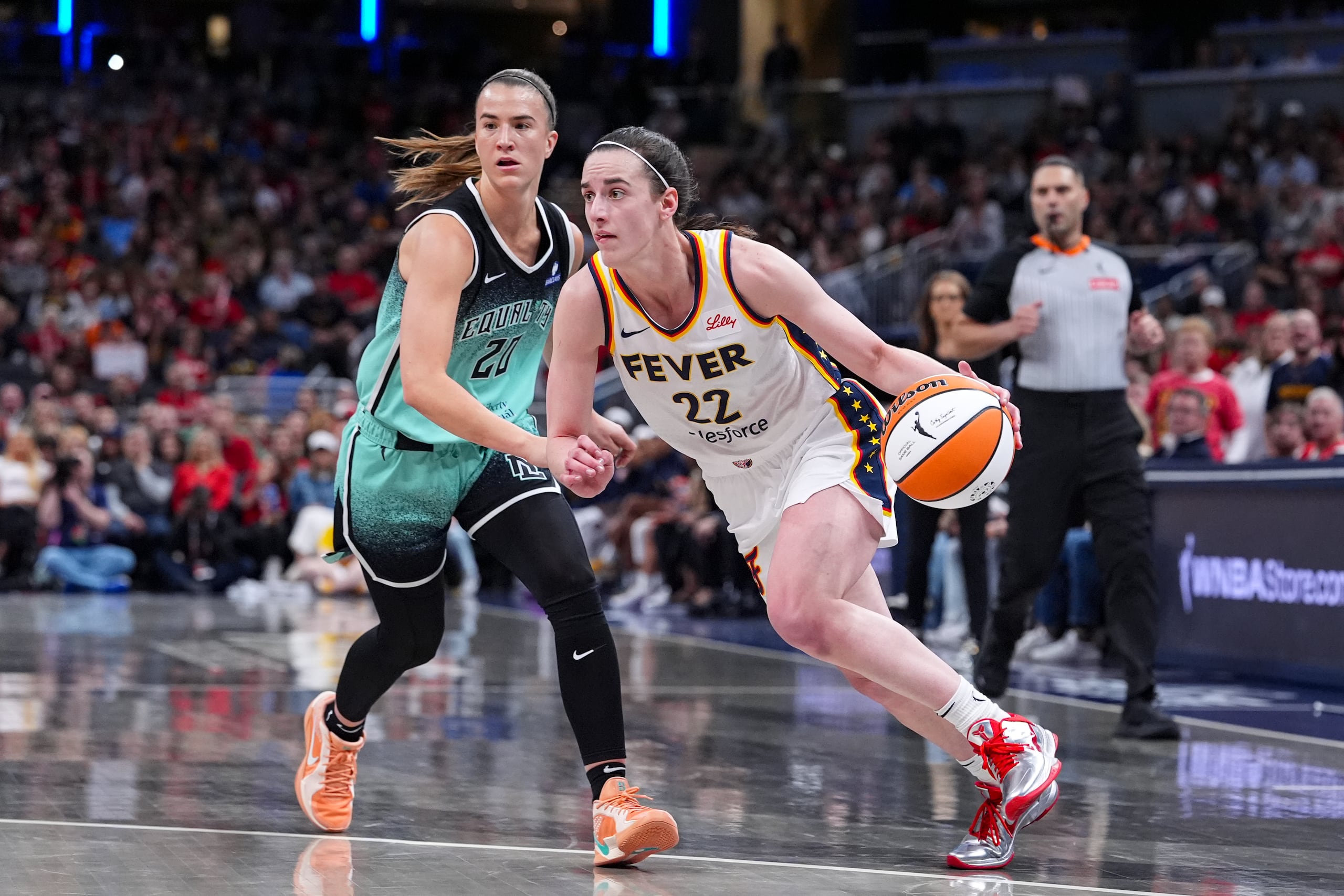 Caitlin Clark (22), de las Fever, ataca ante Sabrina Ionescu (20), de las Liberty.