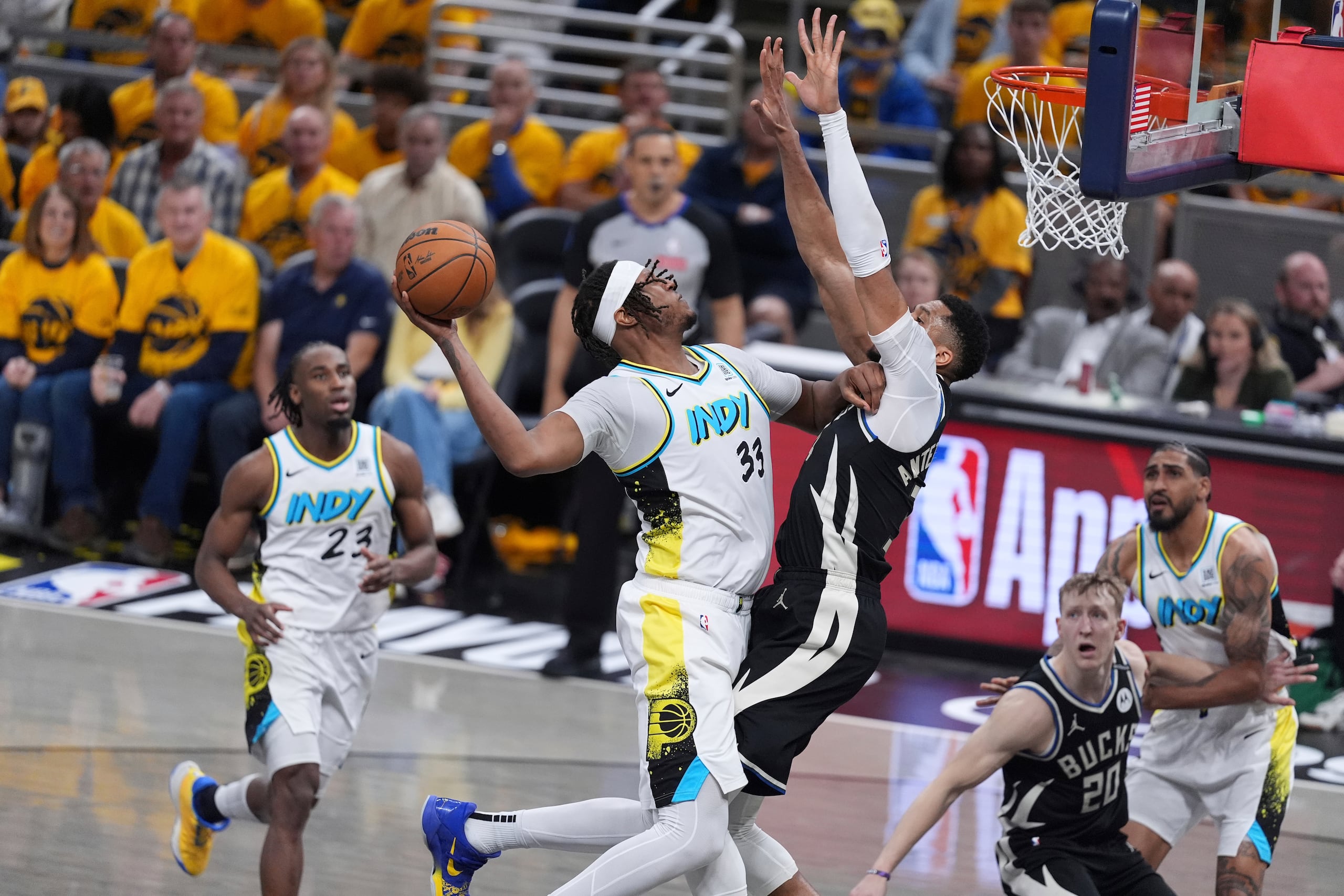 Myles Turner, de los Pacers de Indiana, salta con el balón hacia la canasta mientras lo defiende Giannis Antetokounmpo, de los Bucks de Milwaukee, en el primer juego de la serie de primera ronda.