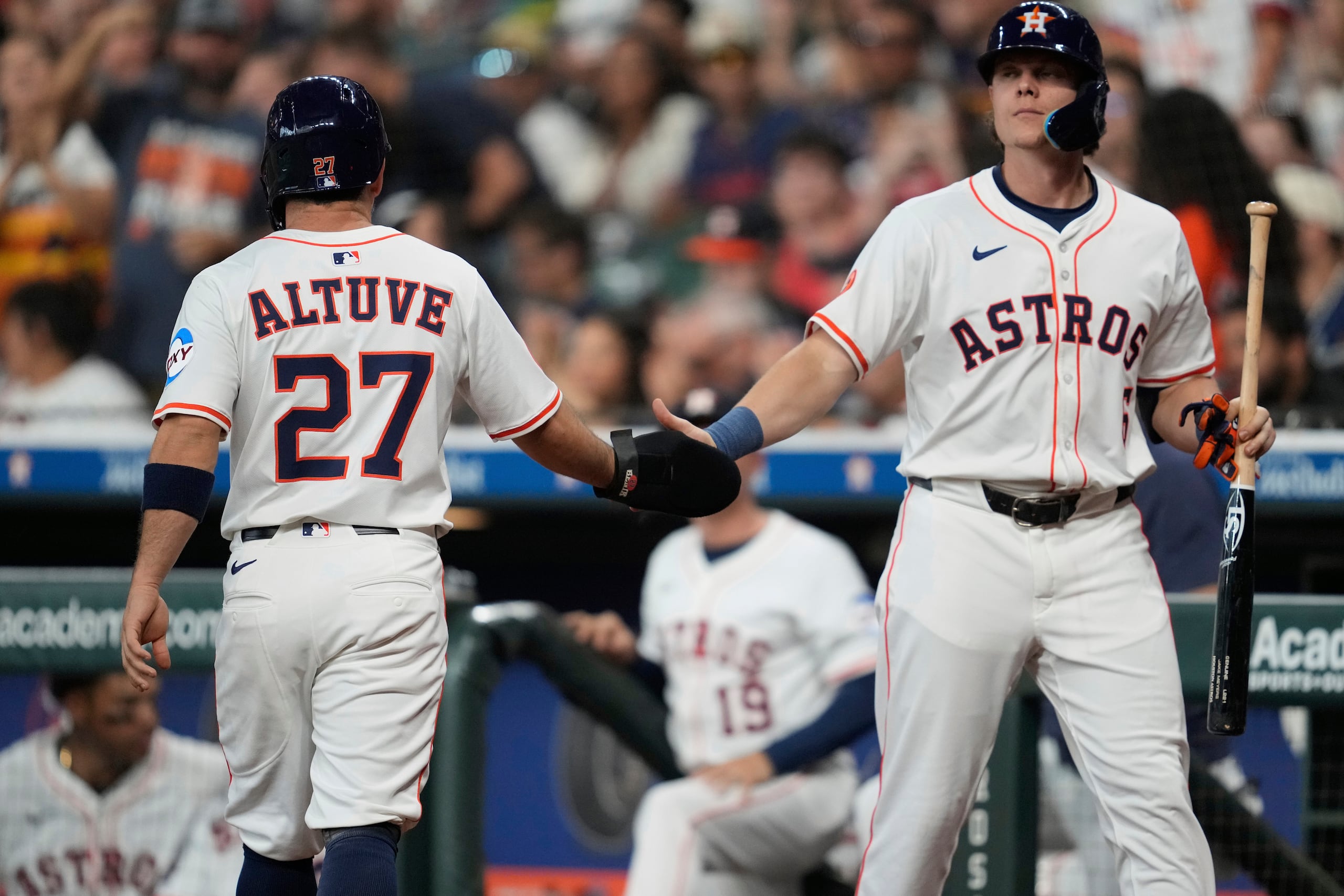 El venezolano José Altuve, de los Astros de Houston, festeja con su copañero Jake Meyers luego de anotar en el juego.