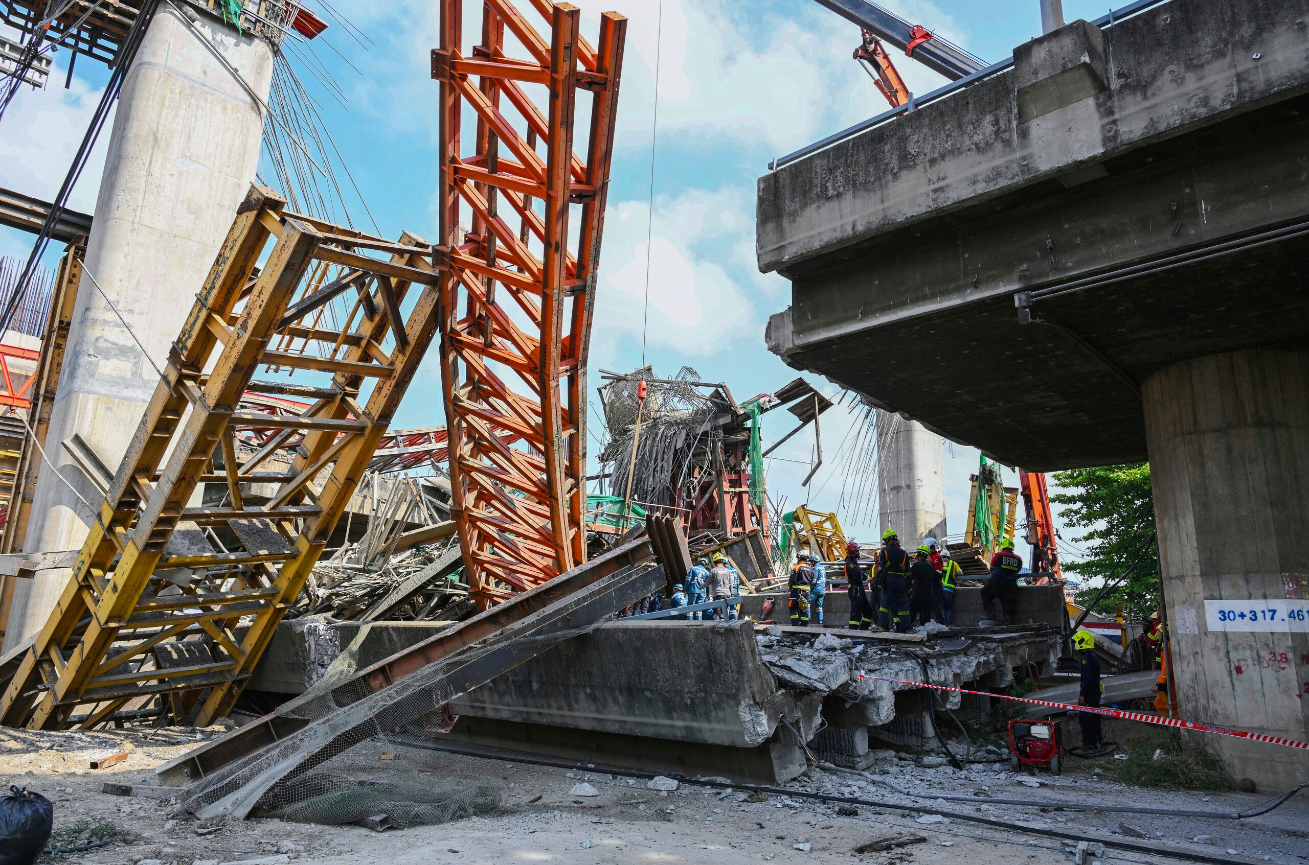 Rescatistas tailandeses trabajan en el lugar donde se derrumbó una carretera elevada en construcción, en Bangkok, Tailandia, el 15 de marzo de 2025. (AP Foto/Panumas Sanguanwong)