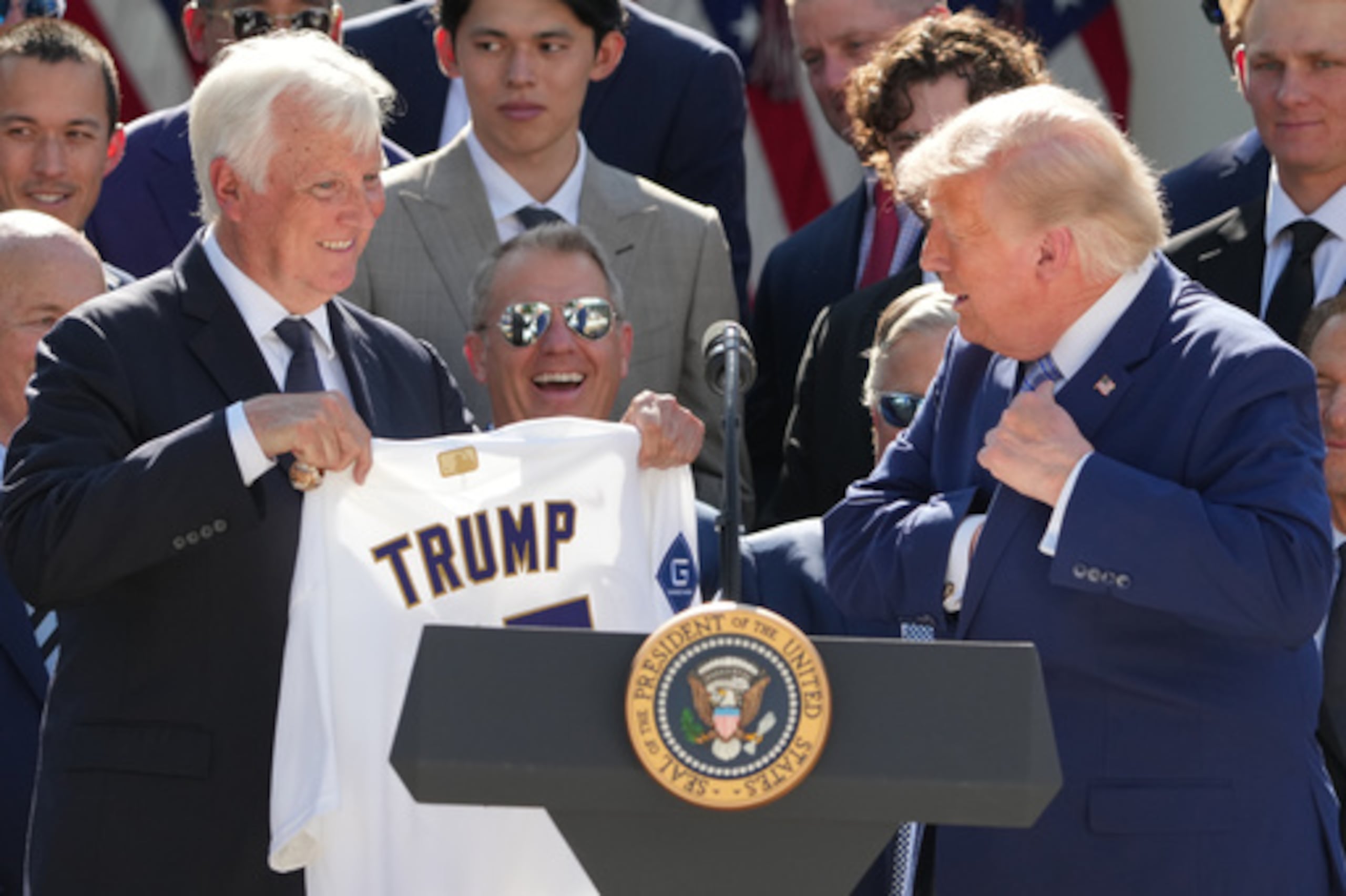 El presidente Donald Trump se guarda un anillo de campeón en el bolsillo mientras el propietario Mark Walter le entrega una camiseta durante un acto en honor a los Dodgers de Los Ángeles, campeones de la Serie Mundial de 2025, celebrado en el Jardín de las Rosas de la Casa Blanca, el jueves 23 de julio de 2026, en Washington. (Foto AP/Alex Brandon)