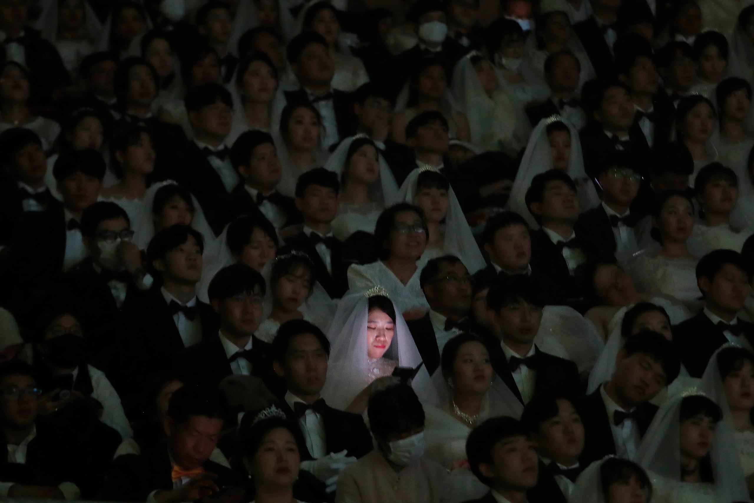 Una novia mira su teléfono durante una ceremonia de bodas masivas en el Cheong Shim Peace World Center en Gapyeong, Corea del Sur, el 7 de febrero de 2020. Parejas surcoreanas y extranjeras intercambiaron o reafirmaron sus votos matrimoniales en la boda masiva organizada por Hak Ja Han Moon, esposa del fallecido reverendo Sun Myung Moon, el controvertido fundador de la Iglesia de la Unificación.