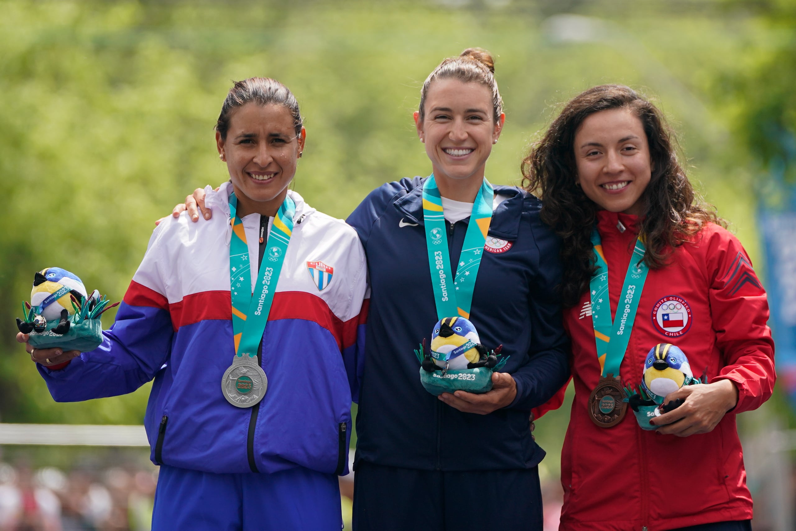 Desde la izquierda, Arlenis Sierra de Cuba; Kristen Faulkener de Estados Unidos y Aranza Villalón de Chile, posan con sus medallas de la prueba de ciclismo de ruta individual contrarreloj en Isla de Maipo, Chile, domingo 22 de octubre, 2023. (AP Foto/Eduardo Verdugo)