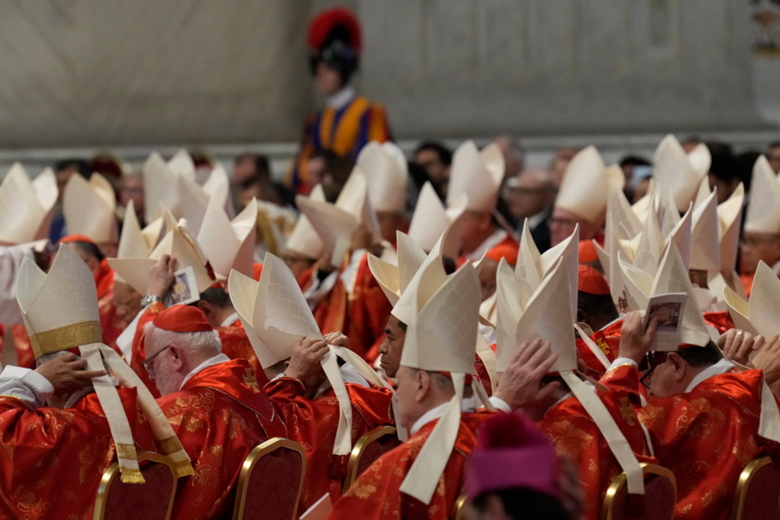 Cardenales ajustan sus mitras durante la misa final celebrada por los cardenales en el interior de la basílica de San Pedro antes del cónclave para elegir a un nuevo papa, en el Vaticano, este miércoles.