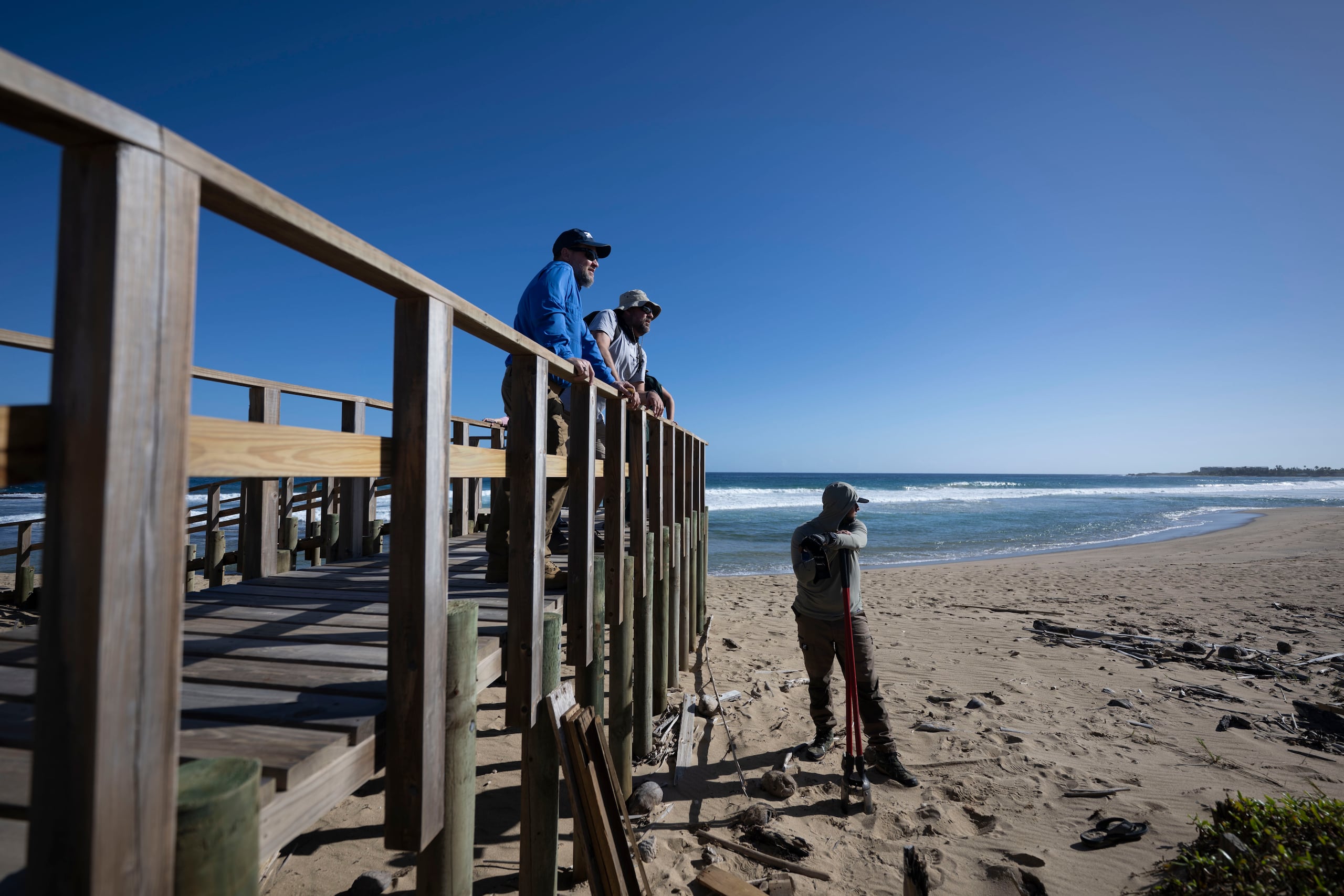 Waldemar Quiles, secretario del DRNA y el doctor Robert J. Mayer Arzuaga, observan el proyecto de restauración de dunas desde uno de los pasadizos que se construyó con fondos de FEMA para evitar tener que pasar por las montañas de arena.