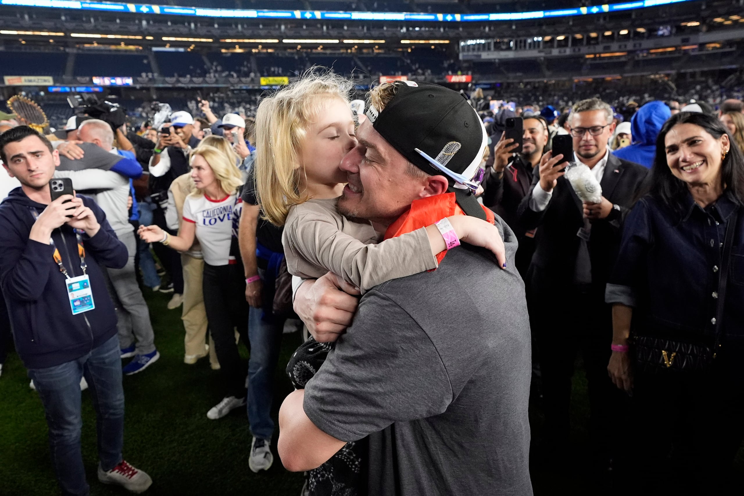Enrique "Kike" Hernández recibe un beso de su hija, Penelope, después de la victoria de los Dodgers de Los Ángeles en el quinto juego para ganar la Serie Mundial.