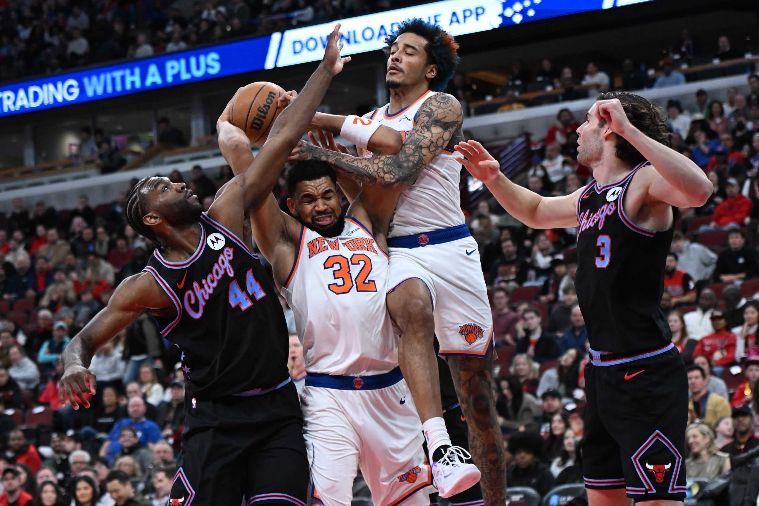 El dominicano Karl-Anthony Towns (32) y Jeremy Sochan (20) de los Knicks de Nueva York luchan por un rebote contra Patrick Williams (44) y Josh Giddy (3) de los Bulls de Chicago durante la primera mitad de un juego de baloncesto de la NBA el domingo 22 de febrero de 2026, en Chicago. (Foto AP/Paul Beaty)