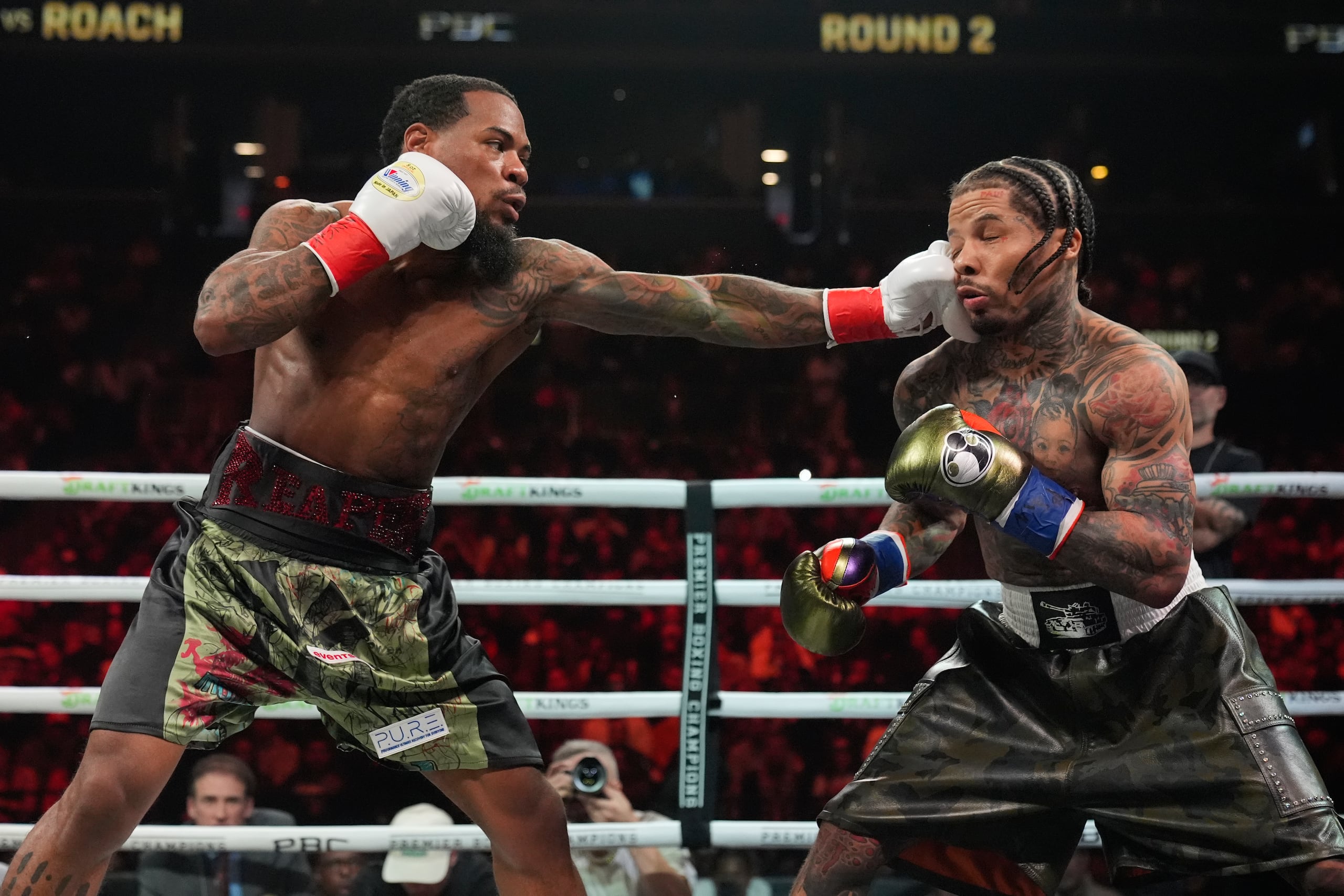 Lamont Roach, izquierda, golpea a Gervonta Davis durante el segundo asalto de la pelea de boxeo por el campeonato de peso ligero de la AMB.