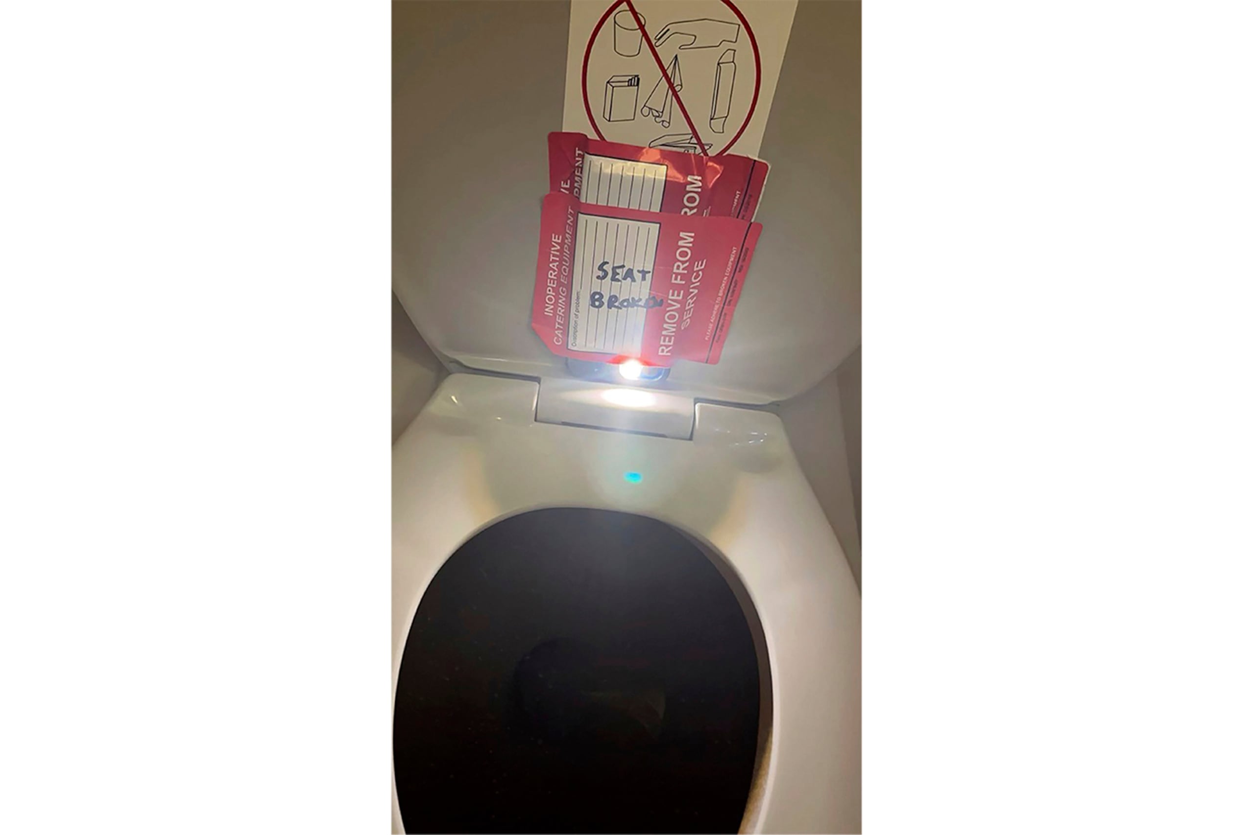 En esta foto proporcionada por el bufete Lewis & Llewellyn LLP, se ve un iPhone pegado con cinta en la parte trasera de la tapa de un inodoro durante un vuelo de American Airlines de Charlotte, Carolina del Norte, a Boston, el 2 de septiembre de 2023.