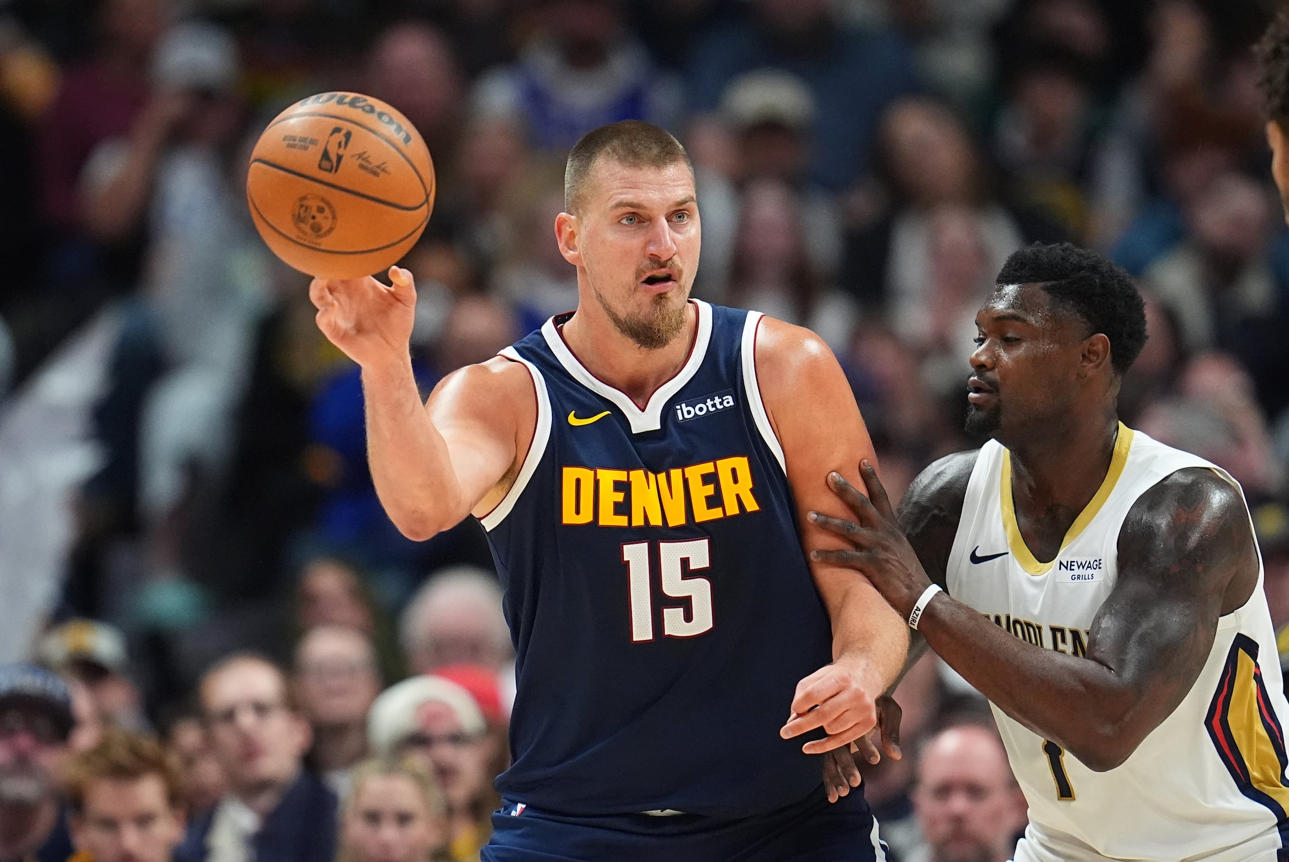 Nikola Jokic (15), de los Nuggets de Denver, pasa el balón ante la presión defensiva de Zion Williamson, de los Pelicans de Nueva Orleans, durante la segunda mitad del juego de baloncesto de la NBA, el miércoles 29 de octubre de 2025, en Denver. (AP Foto/David Zalubowski)