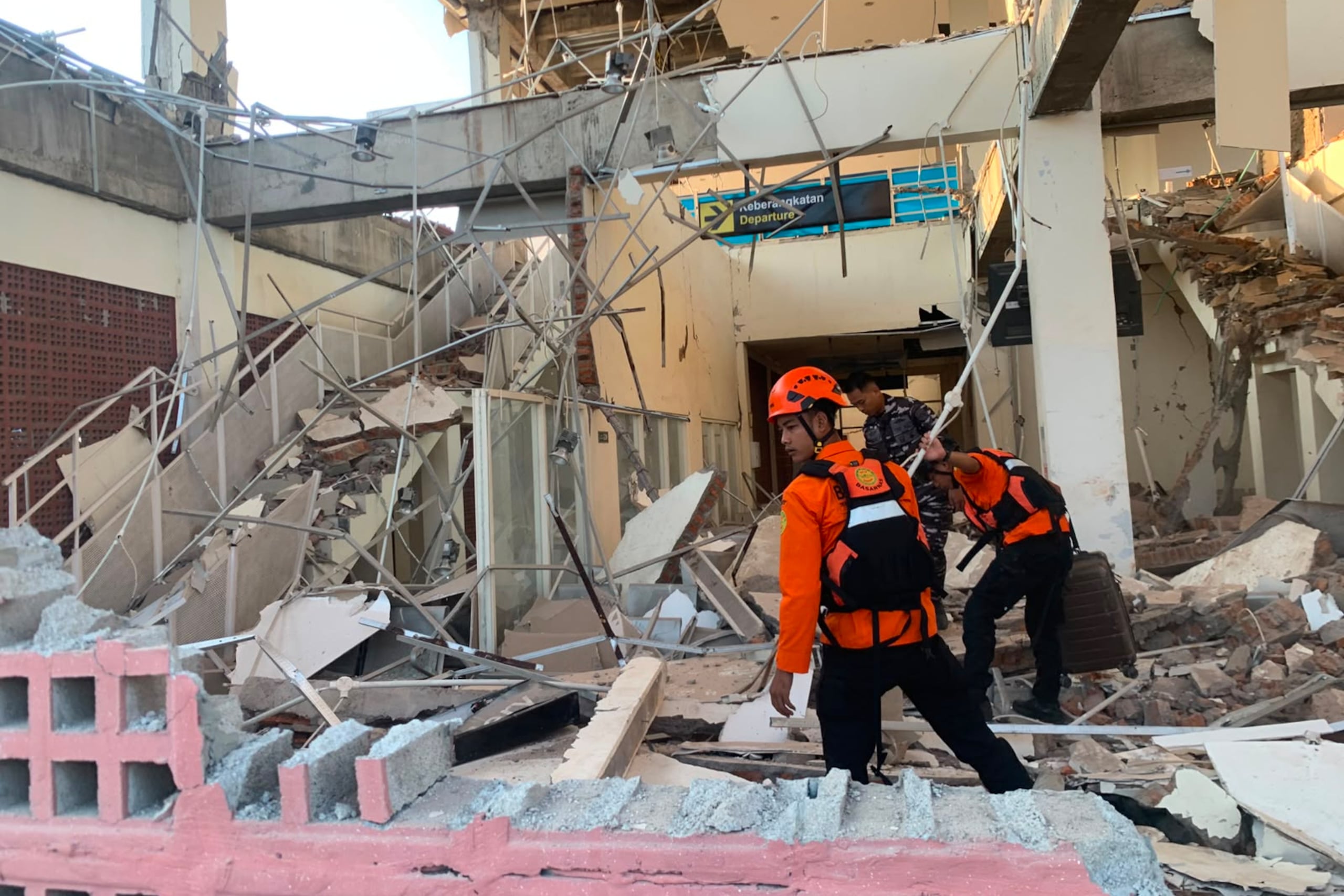 Rescatistas de la Agencia Nacional de Búsqueda y Rescate de Indonesia (BASARNAS) buscan víctimas en un edificio destruido tras el terremoto en Maumere. (BASARNAS vía AP)