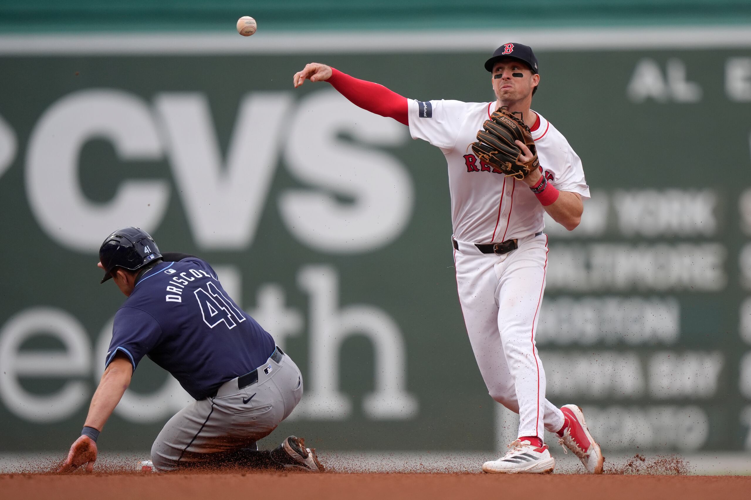 Logan Driscoll (izquierda) de los Rays de Tampa Bay es puesto fuera en segunda base, mientras que el campocorto de los Medias Rojas de Boston, Nick Sogard (derecha) lanza hacia la primera base para completar un doble play en el quinto episodio del juego de béisbol, el domingo 29 de septiembre de 2024, en Boston. (AP Foto/Steven Senne)