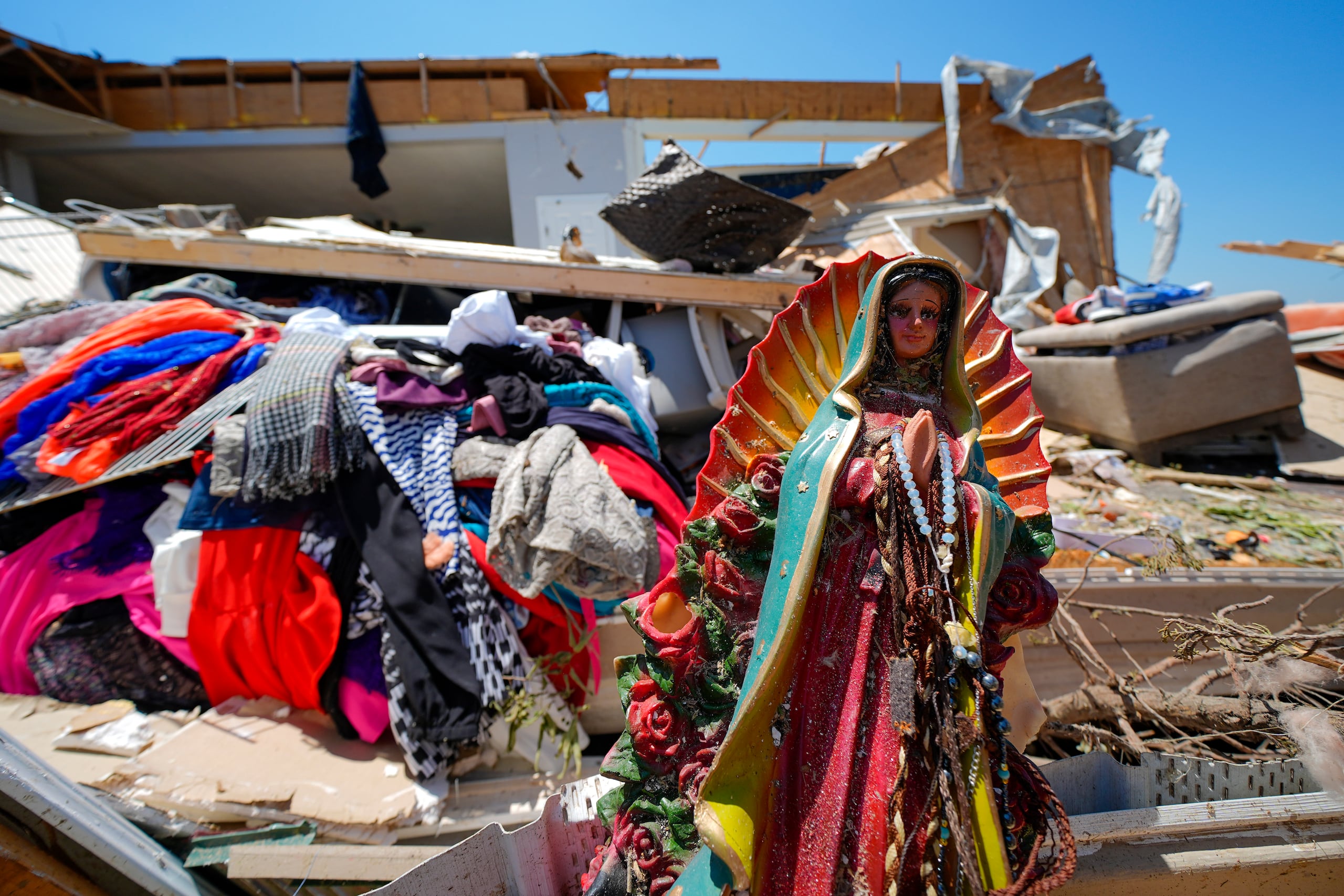 Una estatua de la Virgen de Guadalupe entre los escombros de la casa destruida de Juana Landeros, quien sobrevivió un tornado mortal con su esposo y su hijo de 9 años cuando atravesó la zona la noche previa, el domingo 26 de mayo de 2024 en Valley View, Texas. (AP Foto/Julio Cortez)