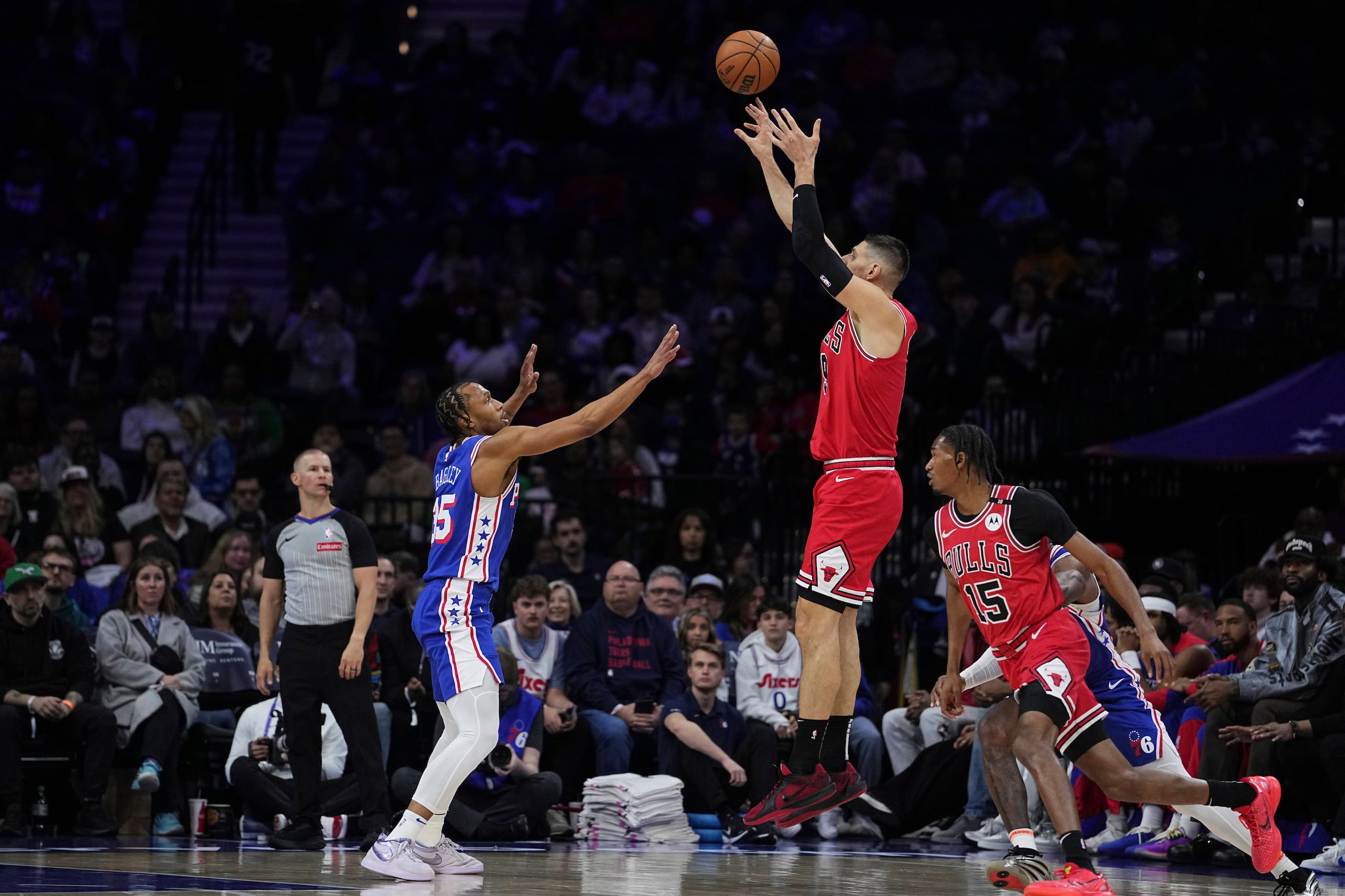 El pívot de los Bulls de Chicago Nikola Vucevic salta para lanzar el balón sobre Isaiah Mobley de los 76ers de Filadelfia en el encuentro de la NBA de hoy domingo.
