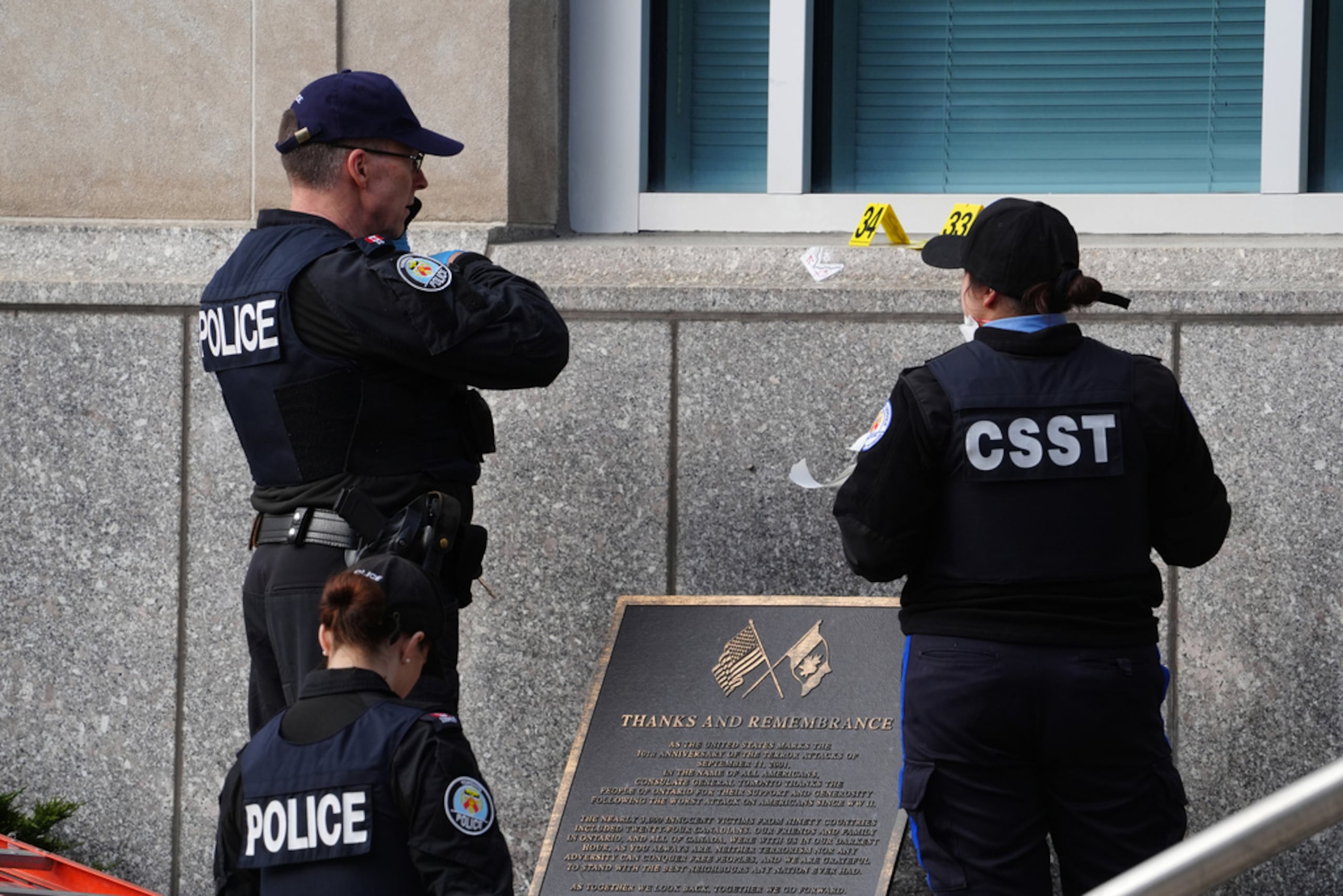 Agentes forenses de la Policía de Toronto buscan evidencia mientras permanecen cerca de una placa en el consulado de Estados Unidos en Toronto, el martes 10 de marzo de 2026.