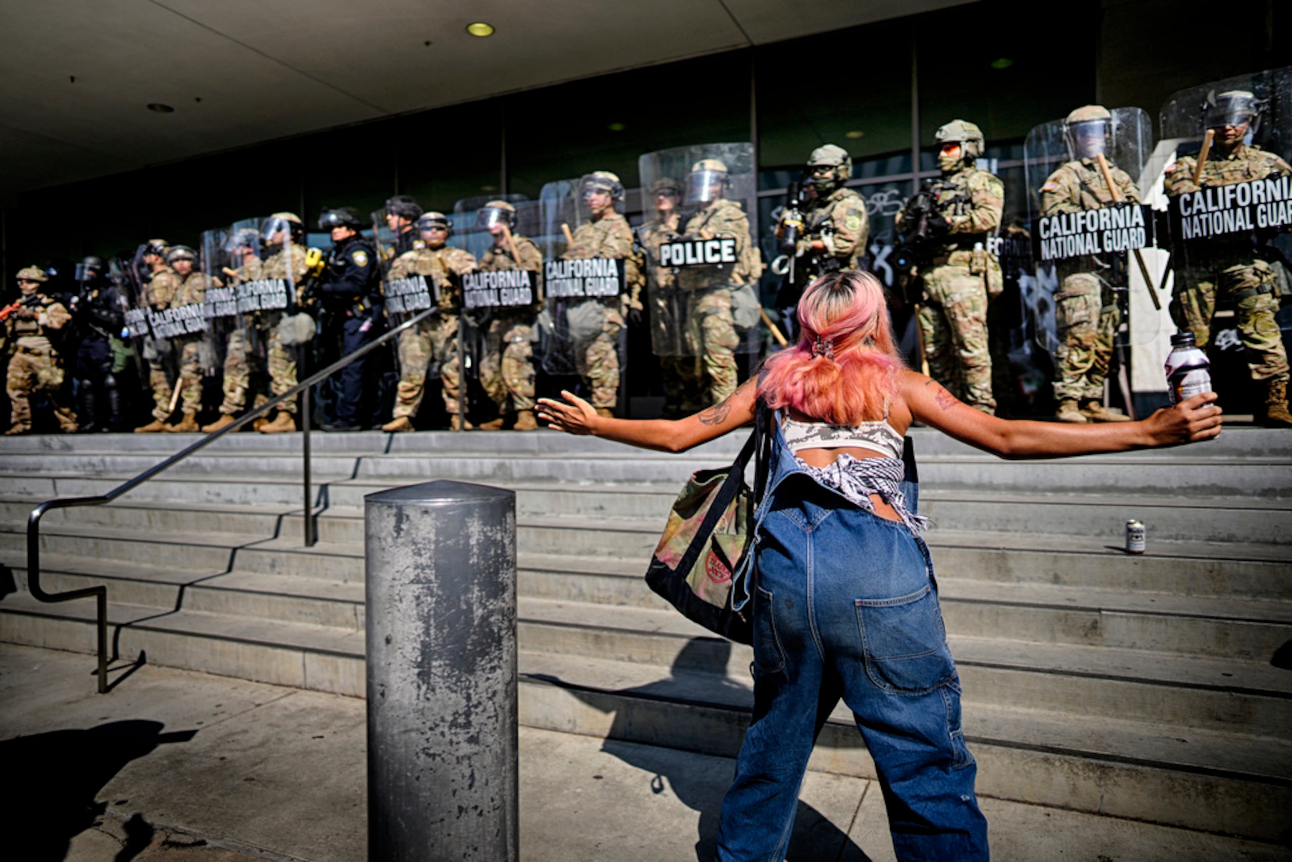 Una manifestante confronta a agentes de la Guardia Nacional en California que protegen un edificio federal en el centro de Los Ángeles, el lunes 9 de junio de 2025.