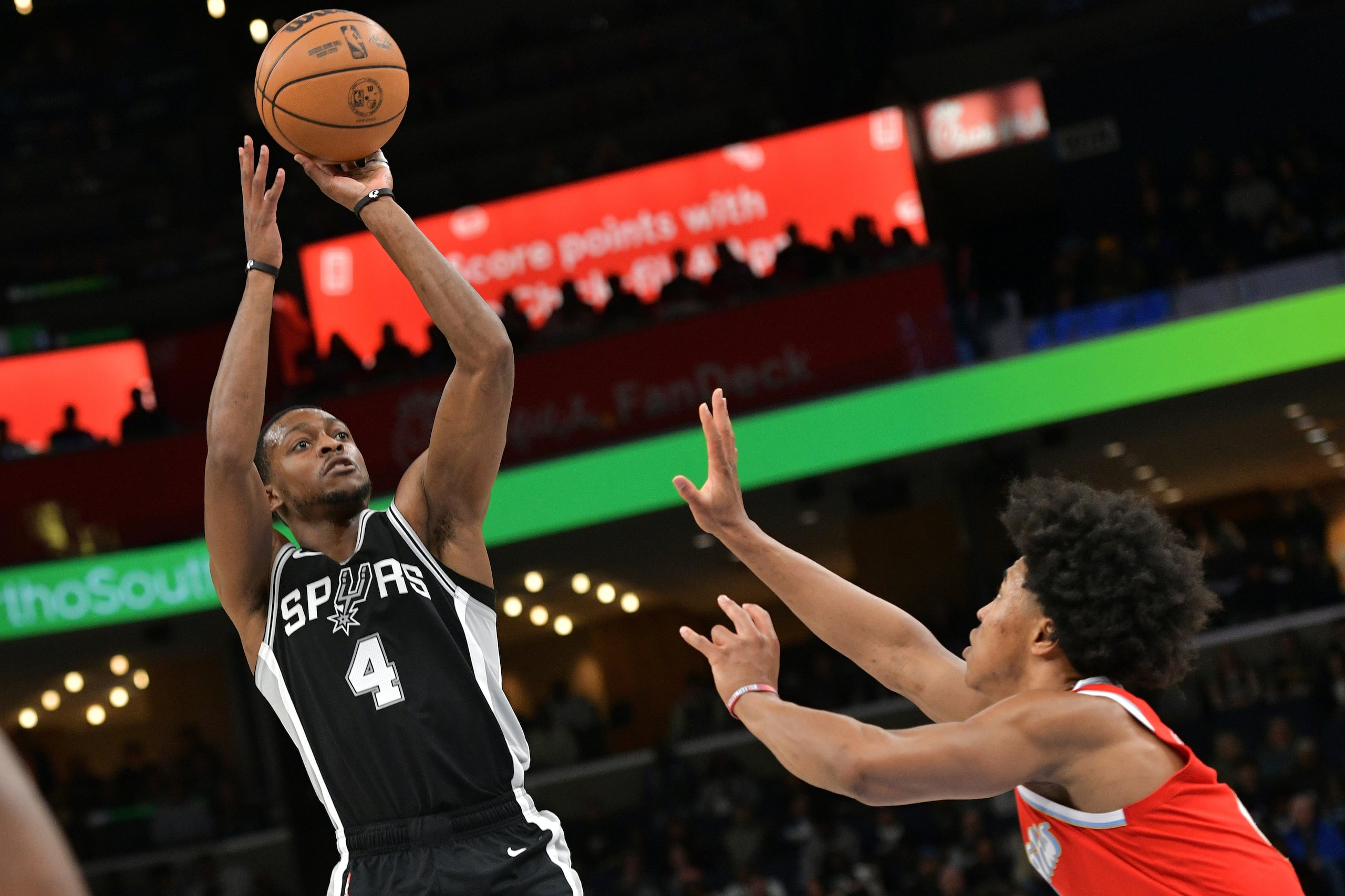 El escolota De'Aaron Fox (4), de los Spurs de San Antonio, dispara a la canasta frente a Jaylen Wells, de los Grizzlies de Memphis, en la primera mitad del partido de baloncesto de la NBA, el sábado 1 de marzo de 2025, en Memphis.
