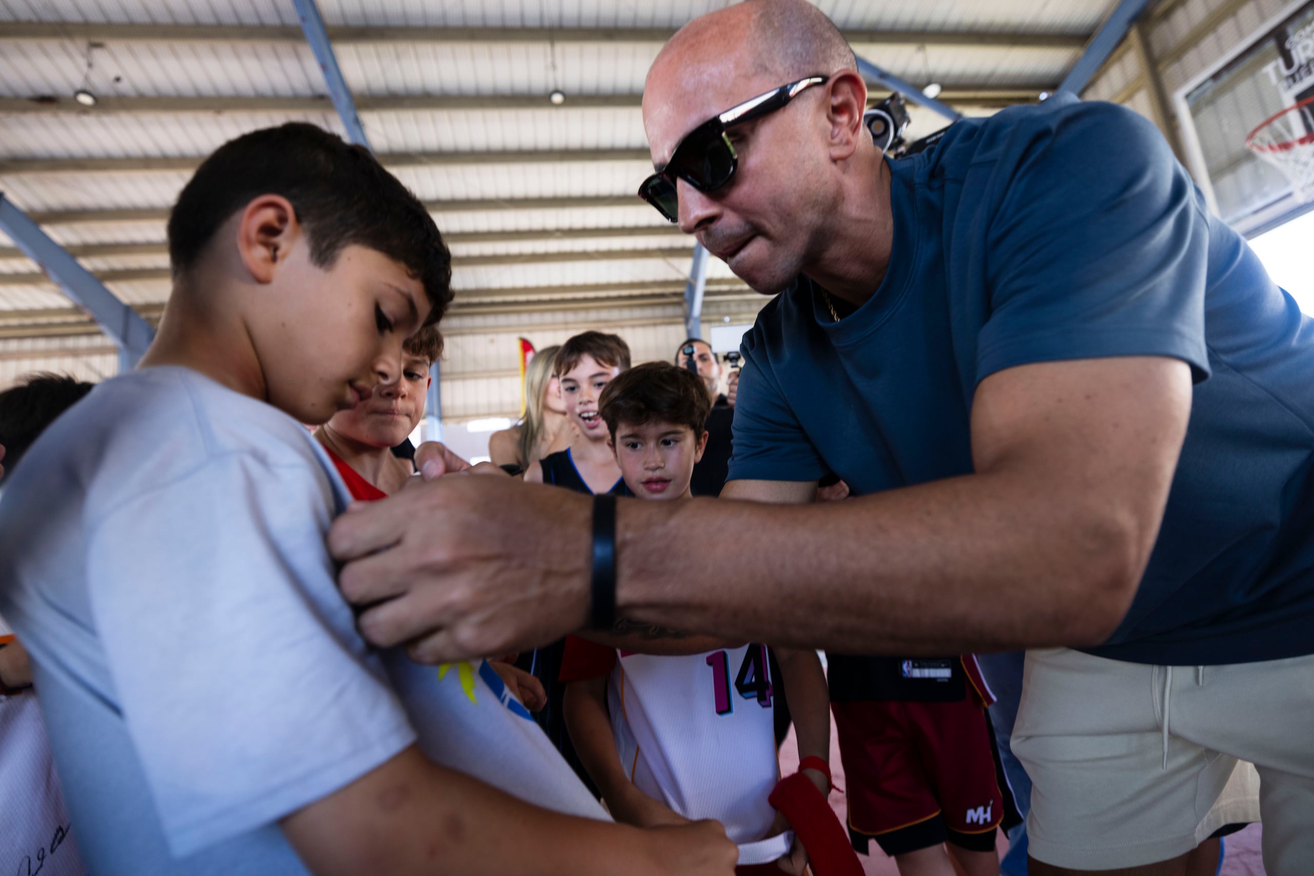 Carlos Arroyo firmó un par de camisetas de niños cuando llegó al residencial Luis Llorens Torres.