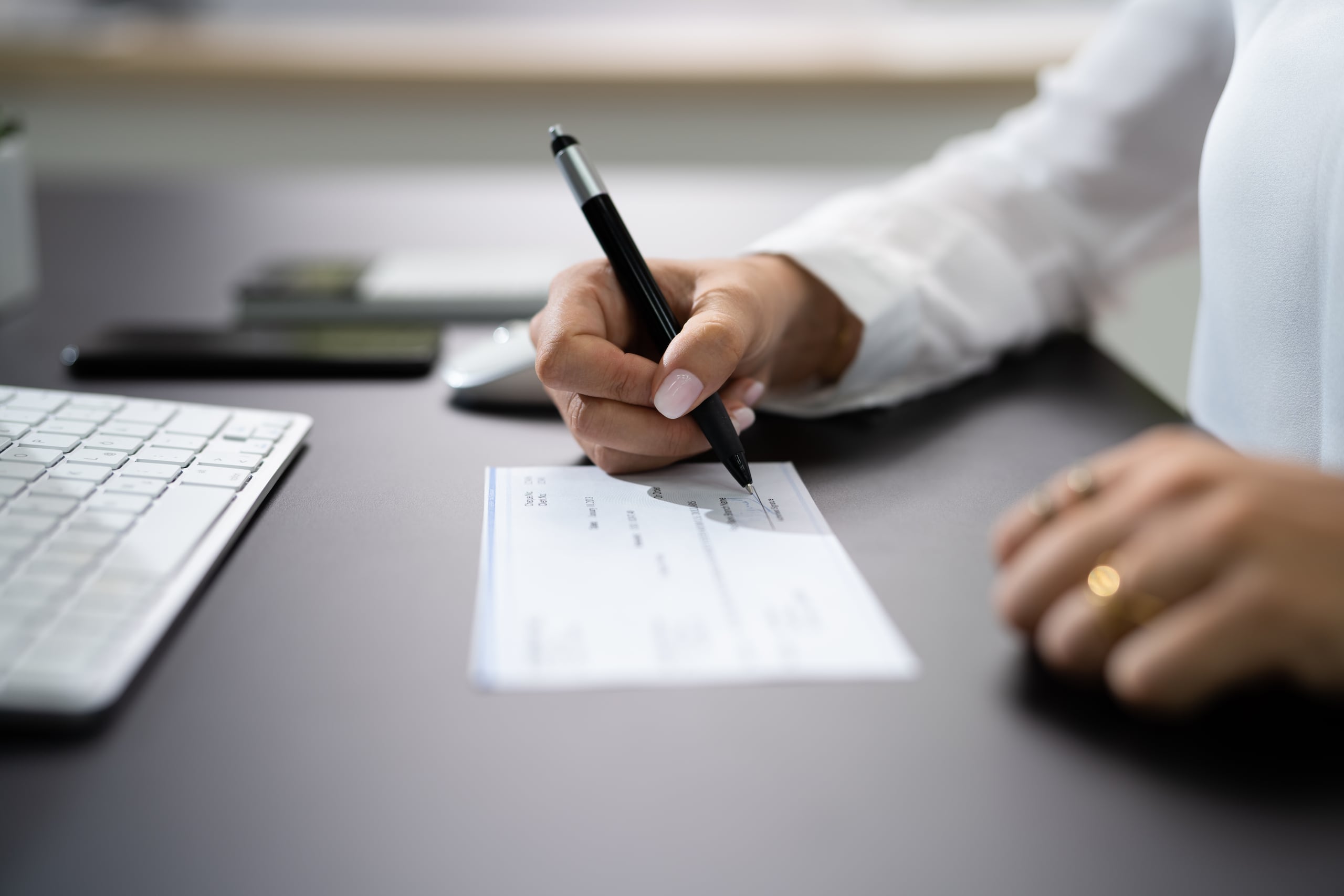 Woman Signing Bank Payroll Check Or Paycheck