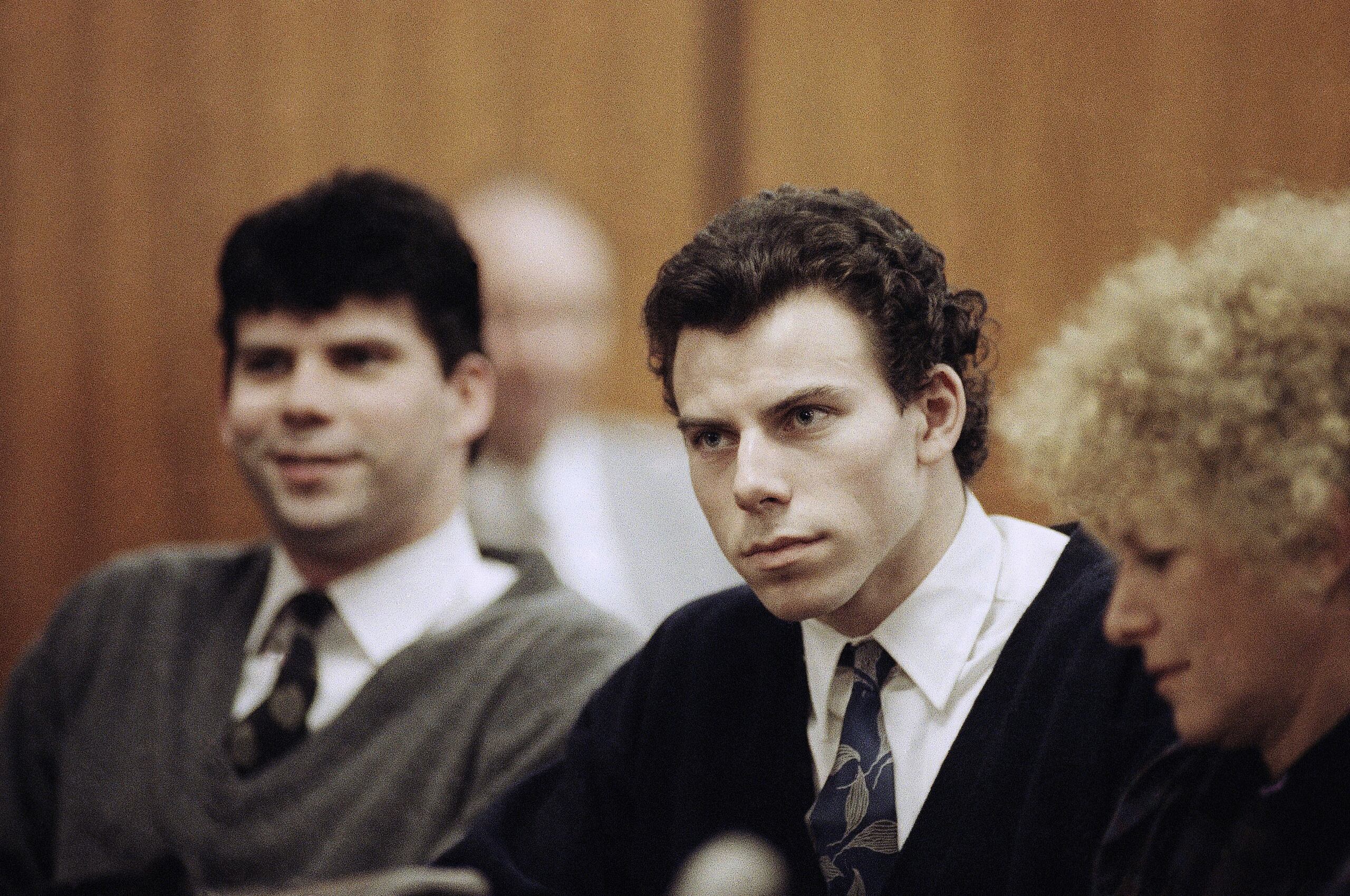 Lyle y Erik Menéndez sentados con su abogada Leslie Abramson en el Tribunal Municipal de Beverly Hills durante una vista el 26 de noviembre de 1990.