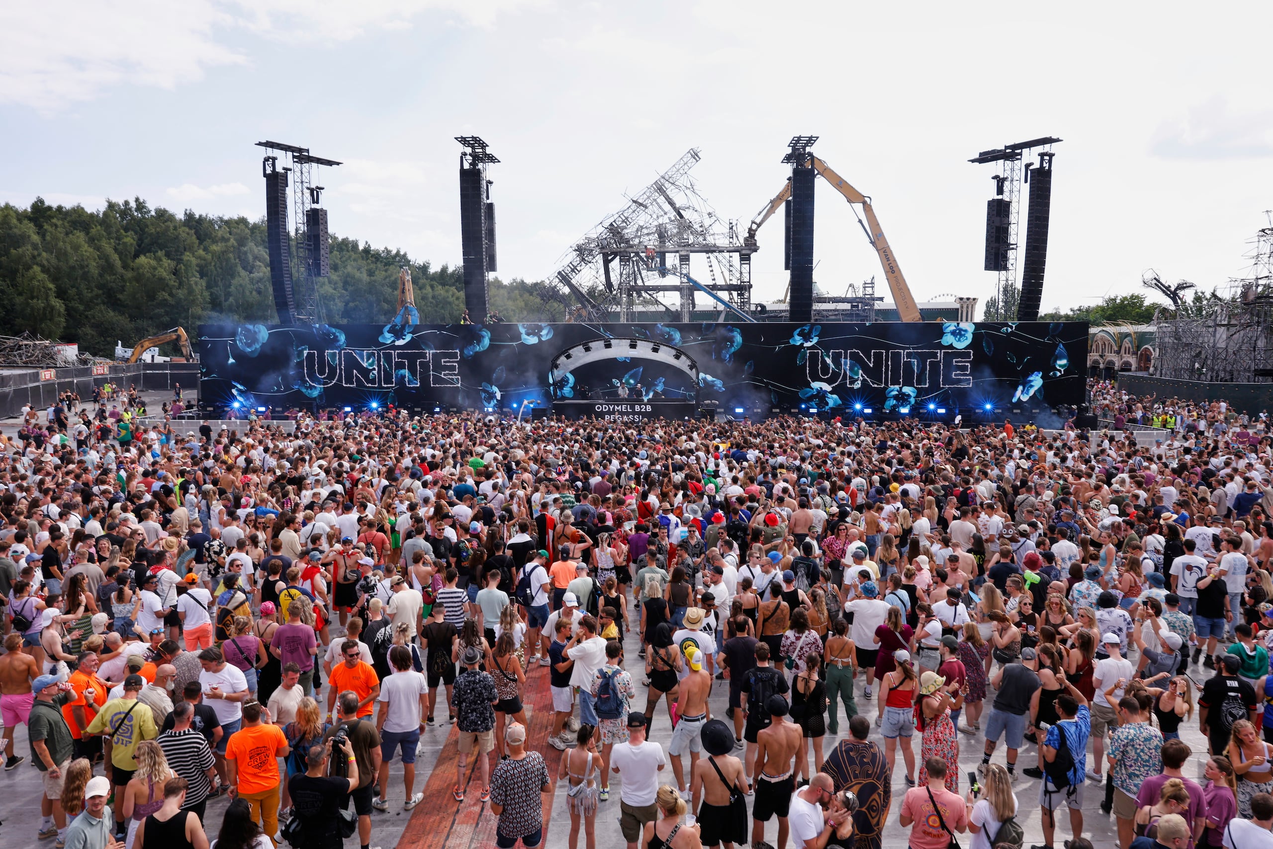 People listen to Odymel B2B and Pegassi performing at the Tomorrowland music festival in Boom, Belgium, Friday, July 18, 2025, two days after a huge fire on Wednesday severely damaged the main stage, rear. (AP Photo/Omar Havana)