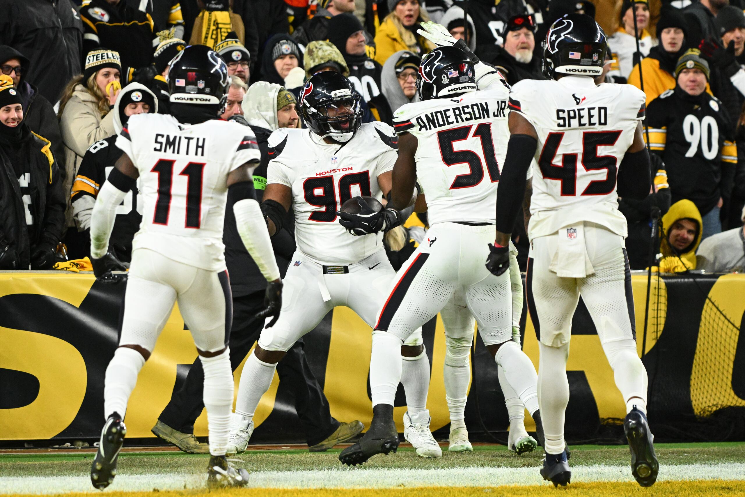 Sheldon Rankins (90), tackle defensivo de los Texans de Houston, celebra con Tremon Smith (11), Will Anderson Jr. (51) y E.J. Speed (45) después de conseguir un touchdown durante la segunda mitad del partido de la ronda de comodines de los playoffs de la NFL en contra de los Steelers de Pittsburgh el lunes 12 de enero de 2026, en Pittsburgh. (AP Foto/Justin Berl)