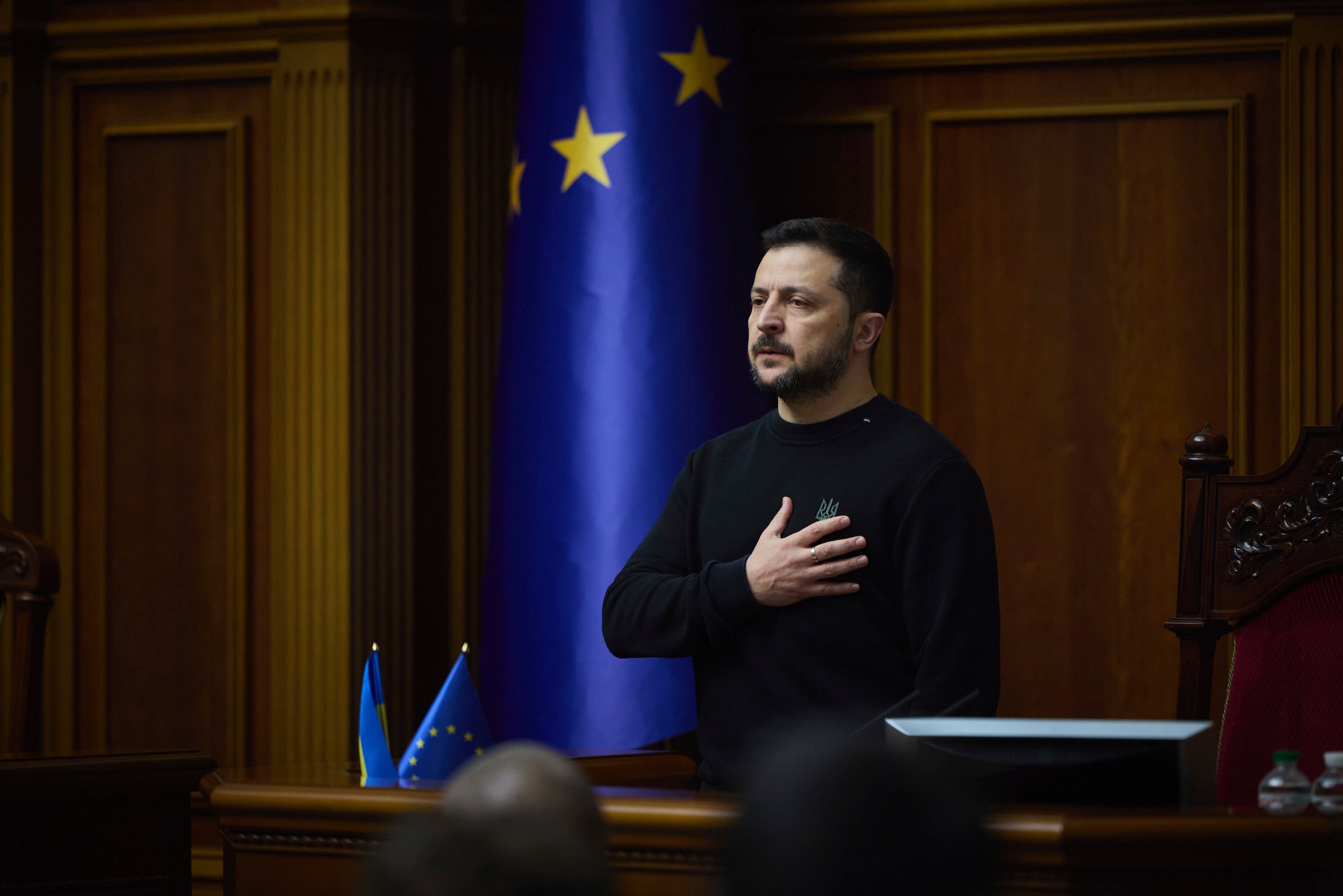 En esta imagen proporcionada por el servicio de prensa del presidente de Ucrania el 19 de noviembre de 2024, el presidente, Volodymyr Zelenskyy, escucha el himno nacional antes de su discurso en el Verkhovna Rada en Kiev, Ucrania.