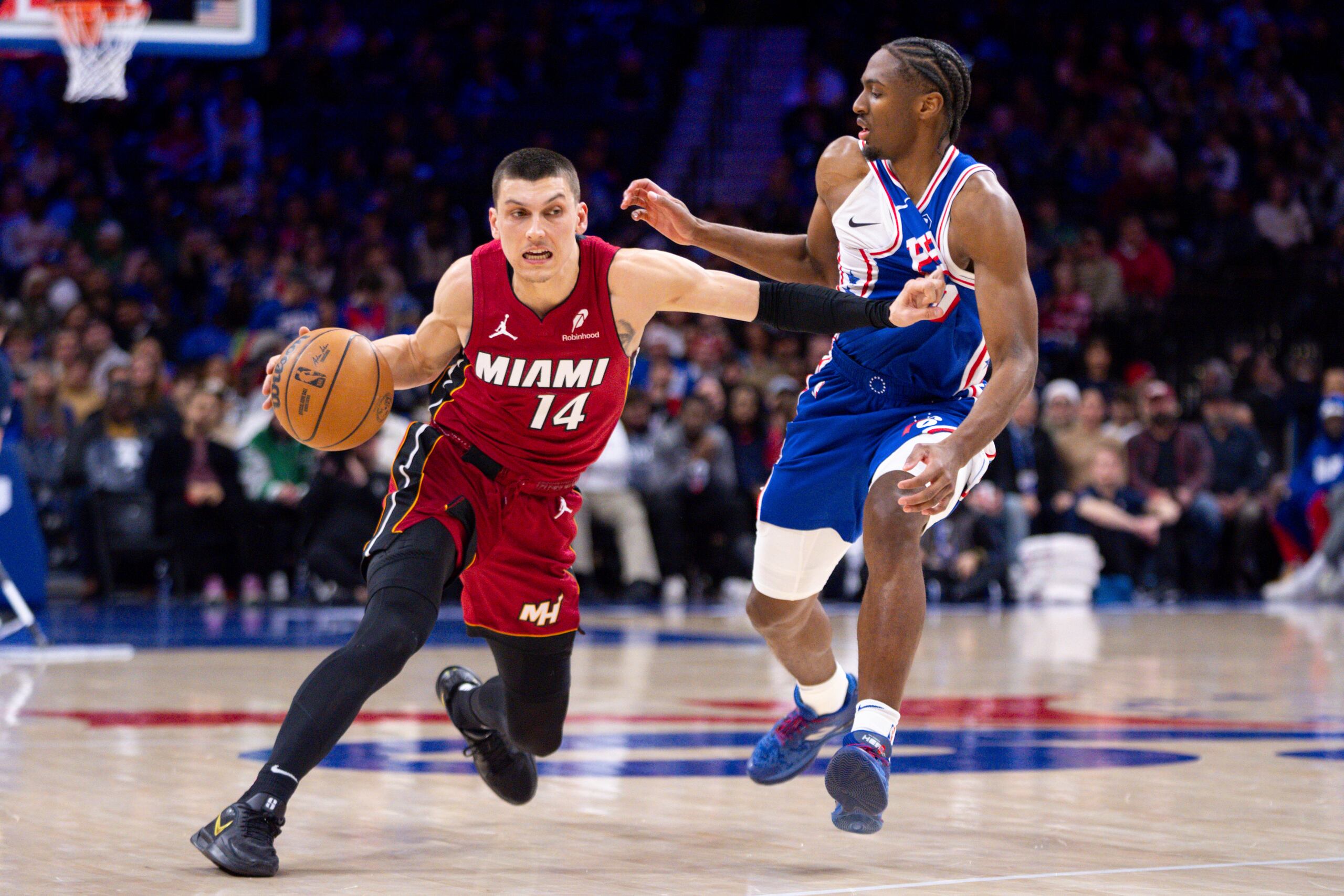 Tyler Herro (izquierda), del Heat de Miami, controla el balón frente a Tyrese Maxey, de los 76ers de Filadelfia.