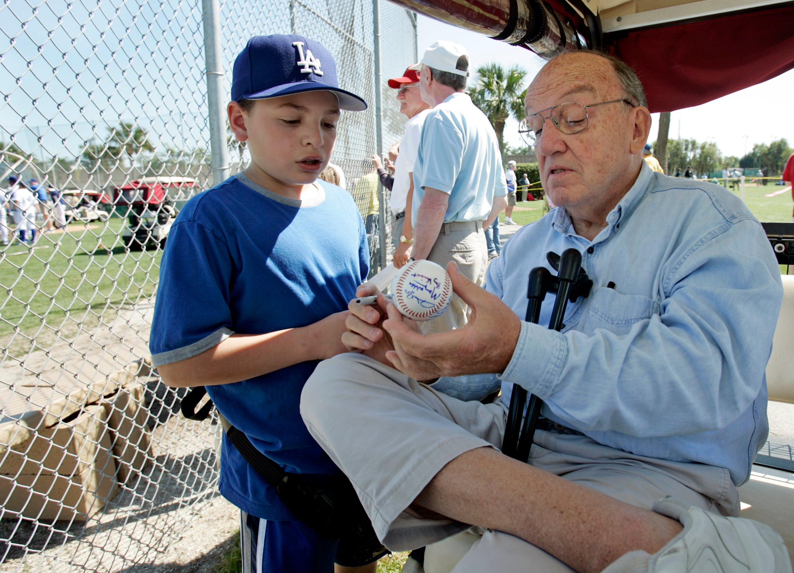 Foto del primero de marzo de 2006 en la que aparece el excomisionado de la MLB, Fay Vincent, firmando un pelota al niño Louis Carrons, de 12 años, en Rancho Cucamonga, California.