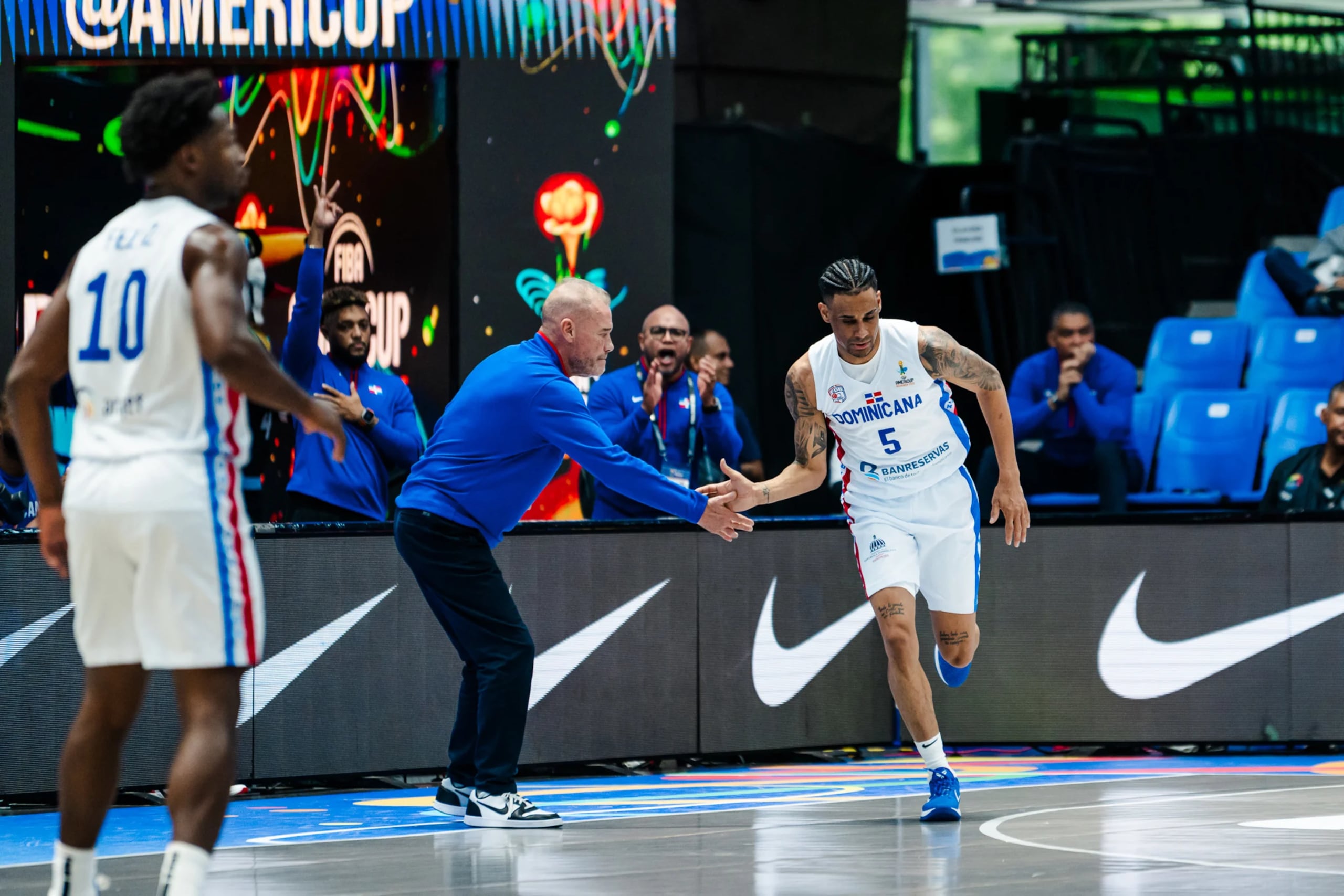 Víctor Liz choca la mano del dirigente argentino Néstor "Che" García tras encestar un triple frente a Brasil en los cuartos de final de la AmeriCup.