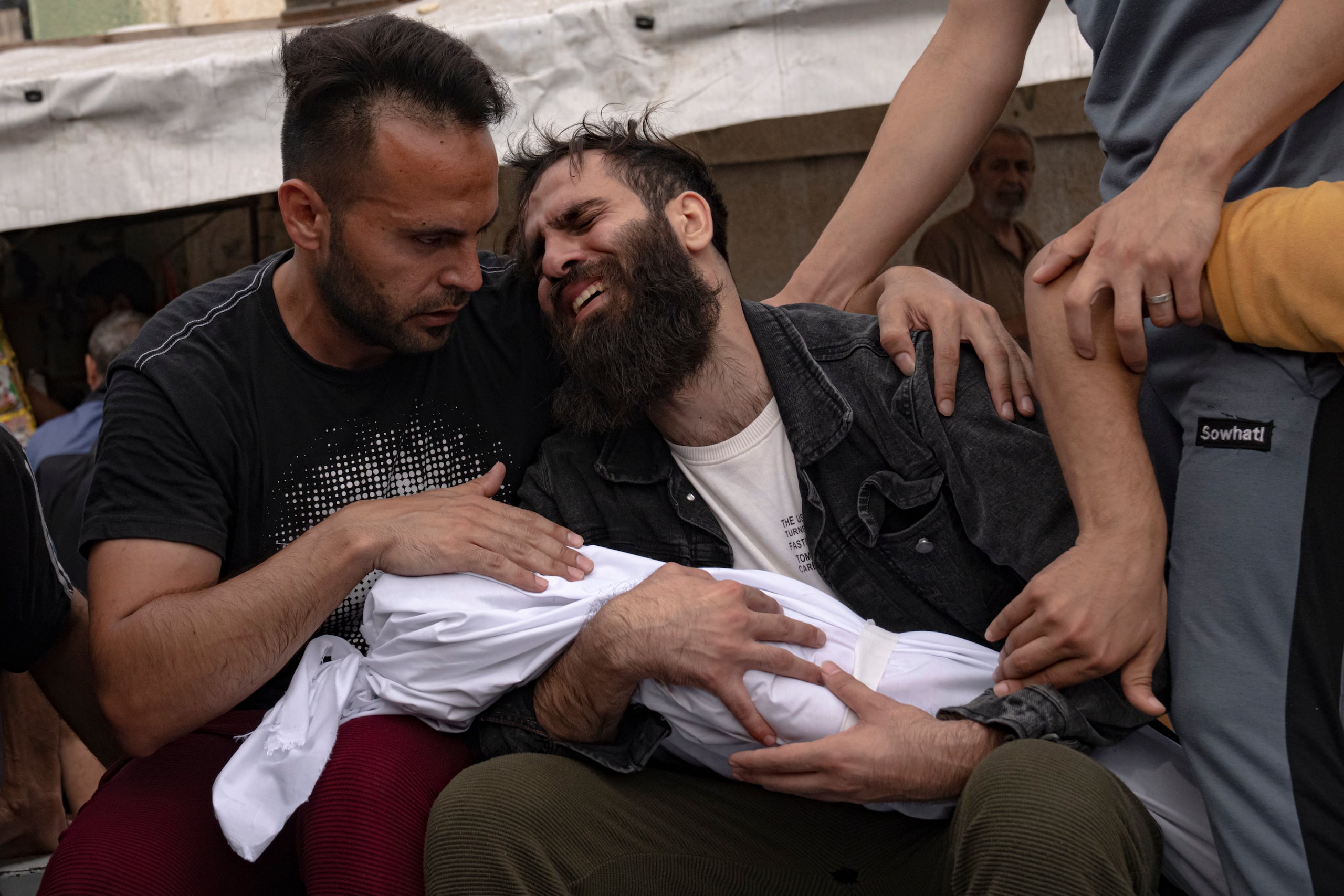 Palestinos lloran a familiares muertos en bombardeos israelíes sobre la Franja de Gaza, en una morgue en Khan Younis, el domigno 29 de octubre de 2023. (AP Foto/Fatima Shbair)