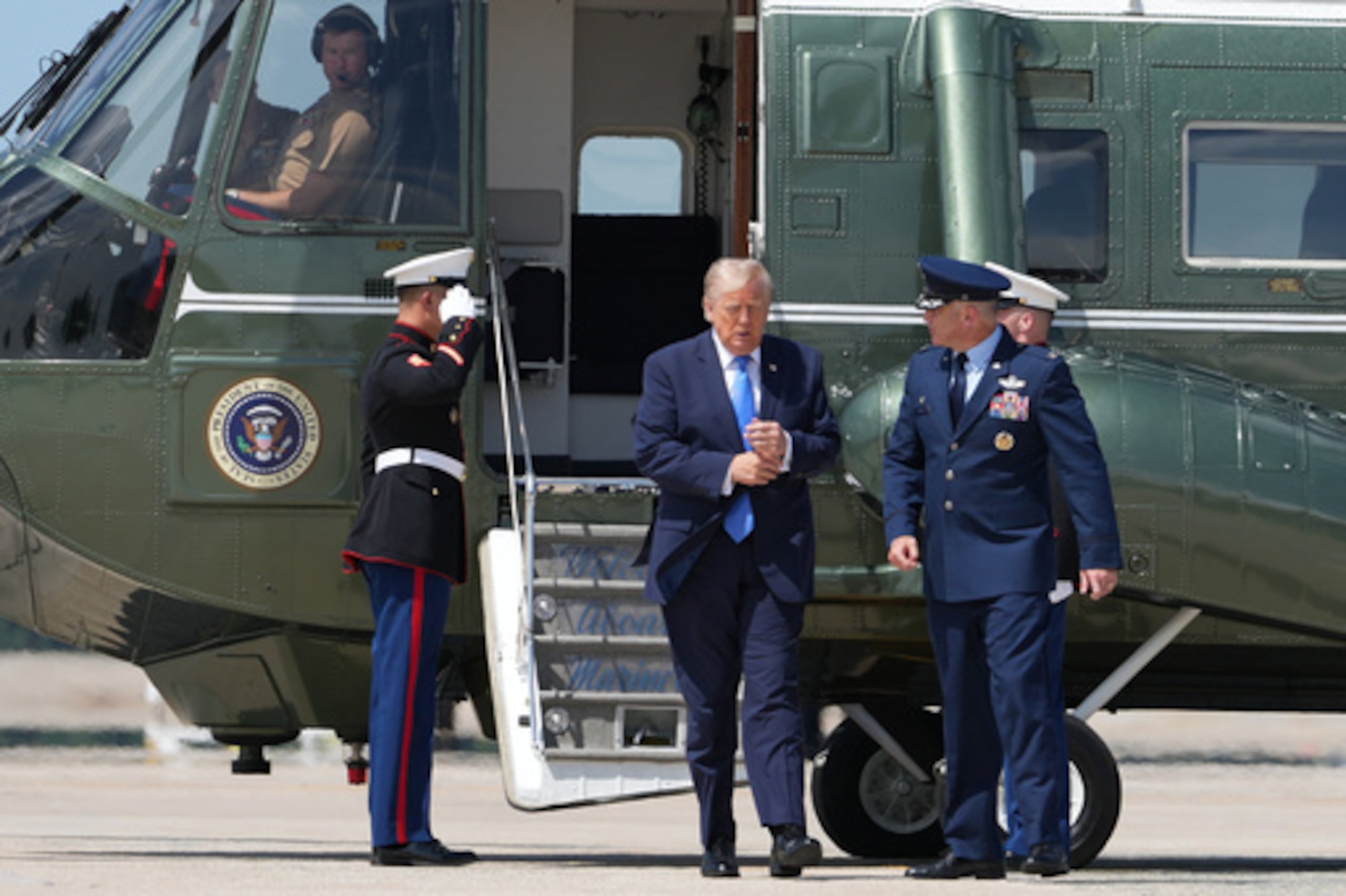 El presidente Donald Trump sale del «Marine One» junto al coronel de la Fuerza Aérea Christopher M. Robinson.