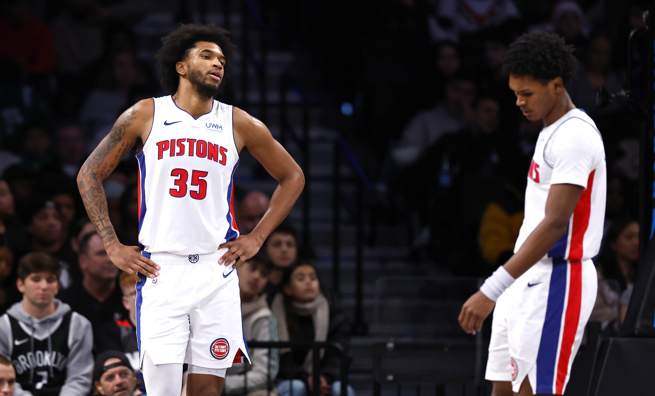 Los aleros Marvin Bagley III (35) y Ausar Thompson, de los Pistons de Detroit, se lamentan tras una falta en favor de los Nets de Brooklyn.