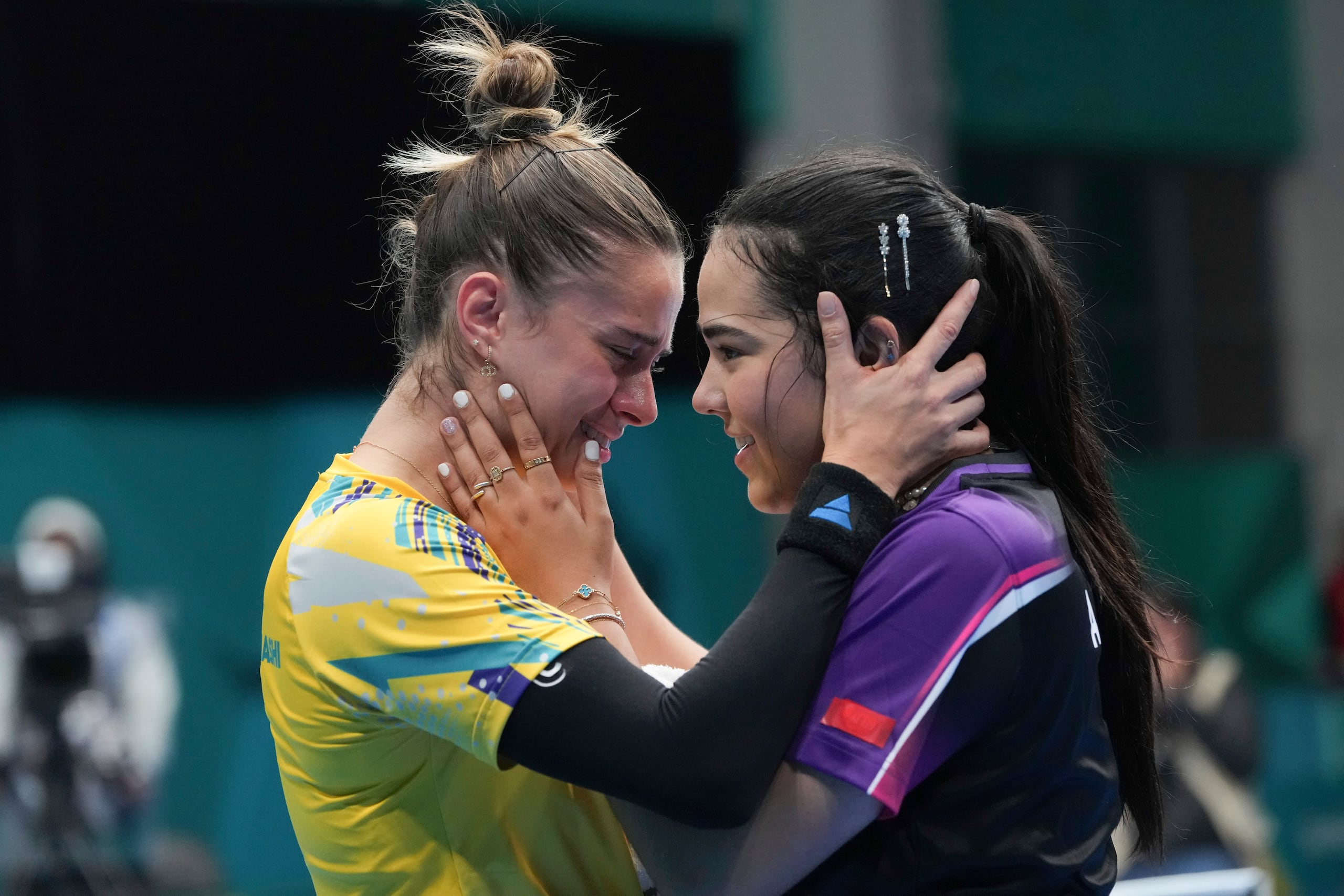 La puertorriqueña Adriana Díaz (derecha) y la brasileña Bruna Takahashi se abrazan tras la conclusión de la final de sencillos.