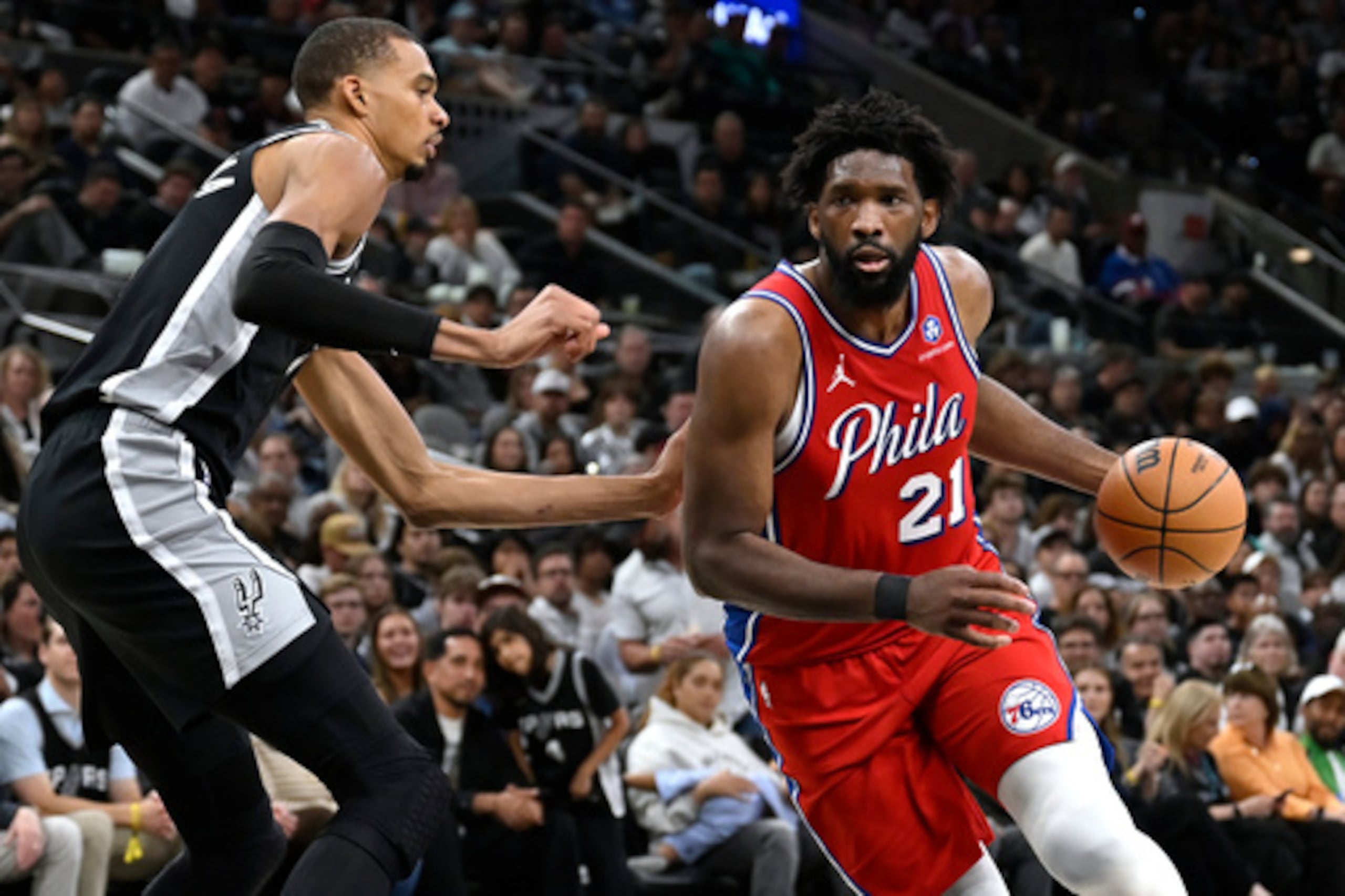 Joel Embiid (21) conduce contra el pívot de los San Antonio Spurs Victor Wembanyama.